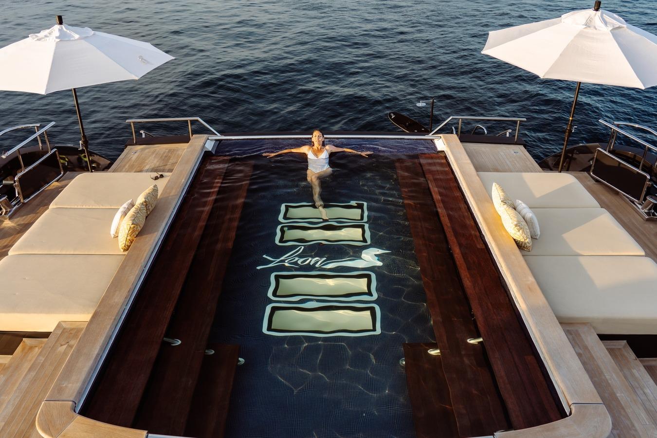 Luxurious 2010 Icon Motor Yacht with pool, sun loungers, and umbrellas on deck.