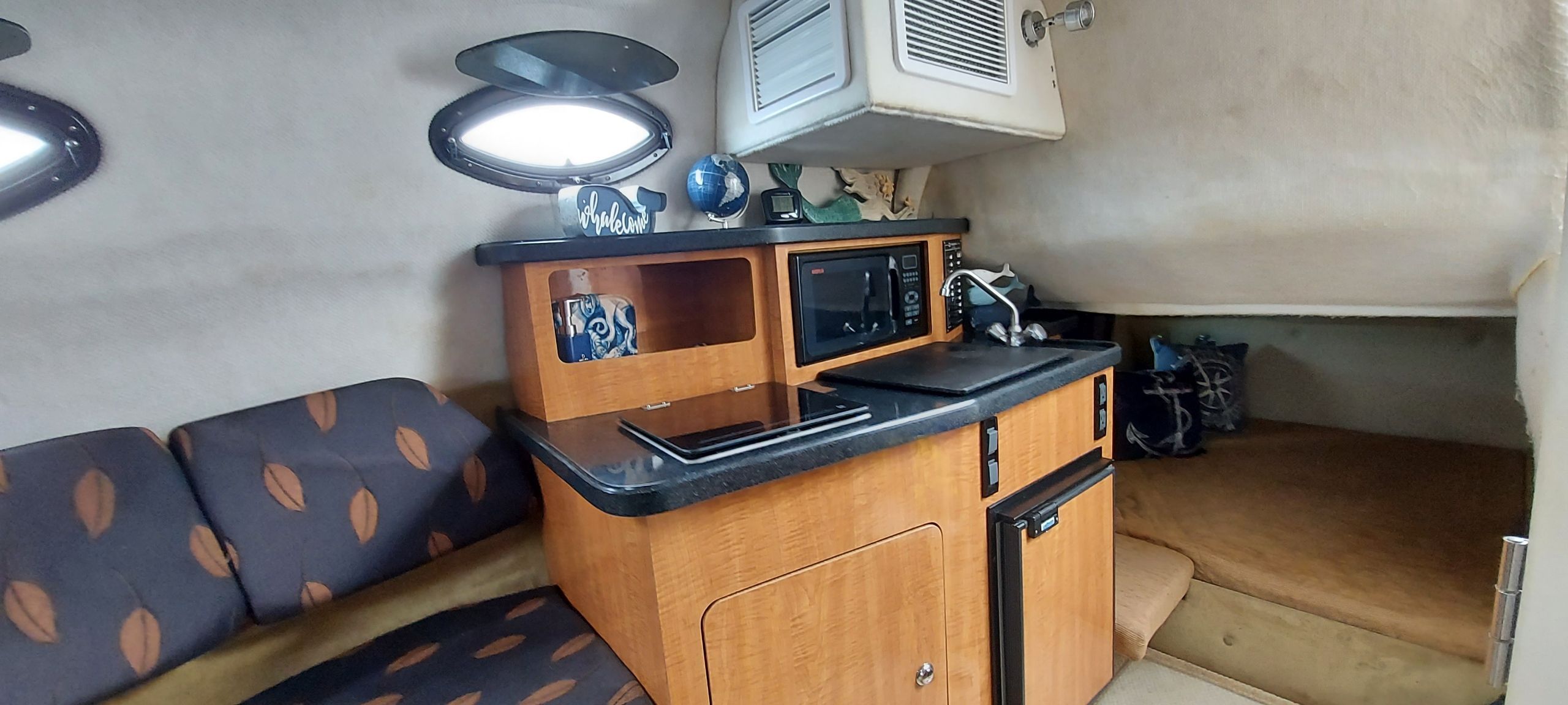 Interior of a 2004 Regal Commodore 2465 yacht with kitchenette and seating area.