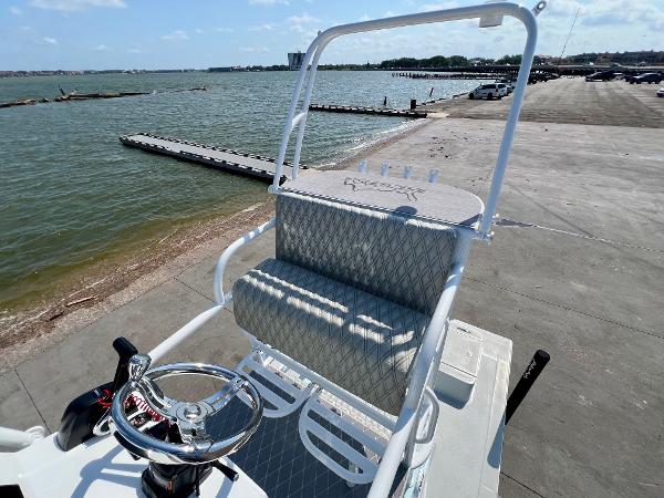 2022 Shallow Sport 20 Classic boat at dockside with steering wheel and seating, overlooking water.