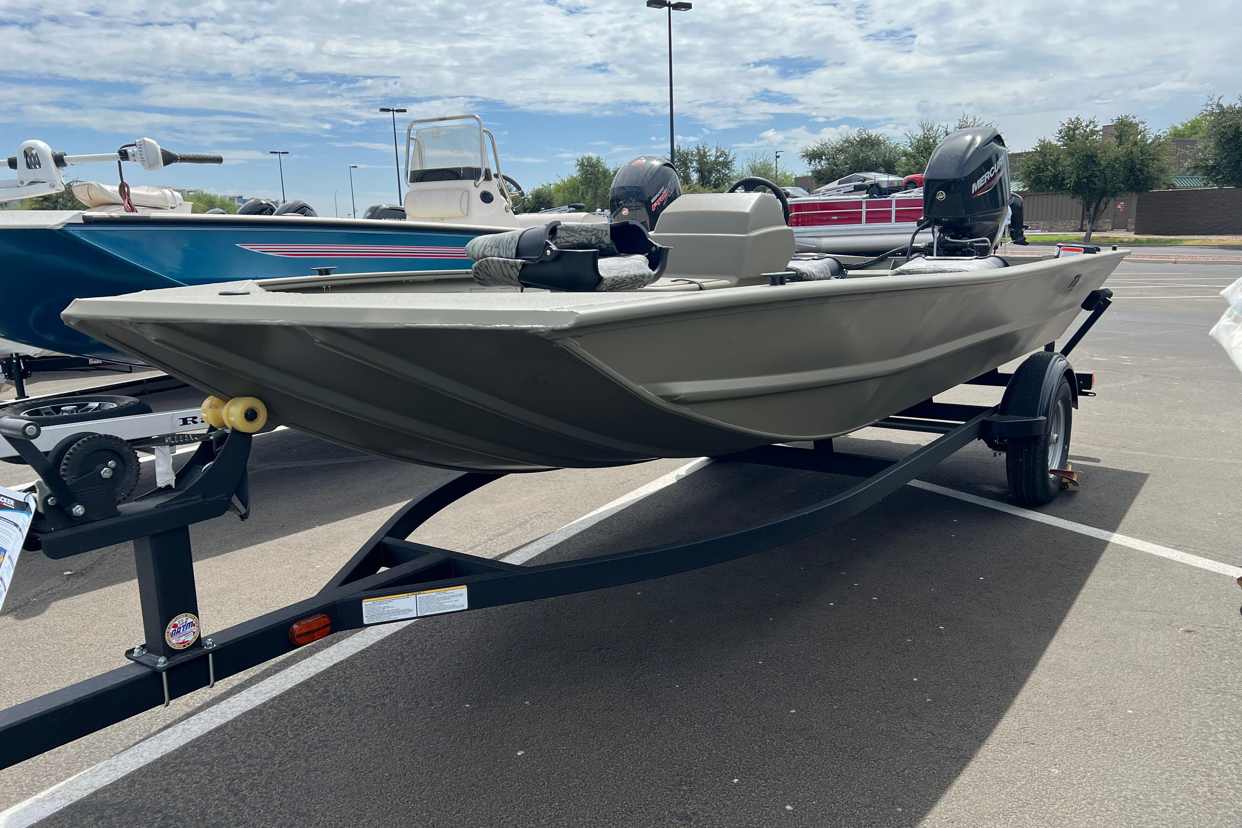 2026 Tracker Grizzly 1754 SC boat on trailer, parked outdoors under cloudy sky.