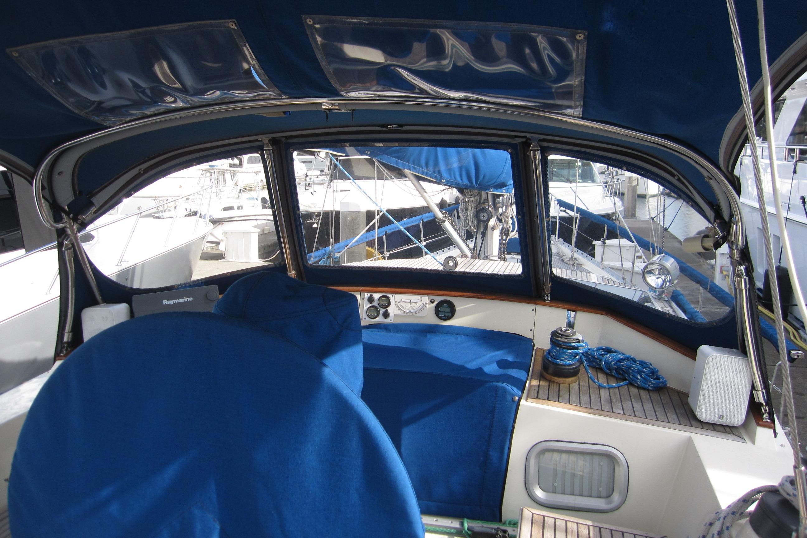 Cockpit of 1983 Nauticat 43 sailboat with blue covers and nautical equipment.