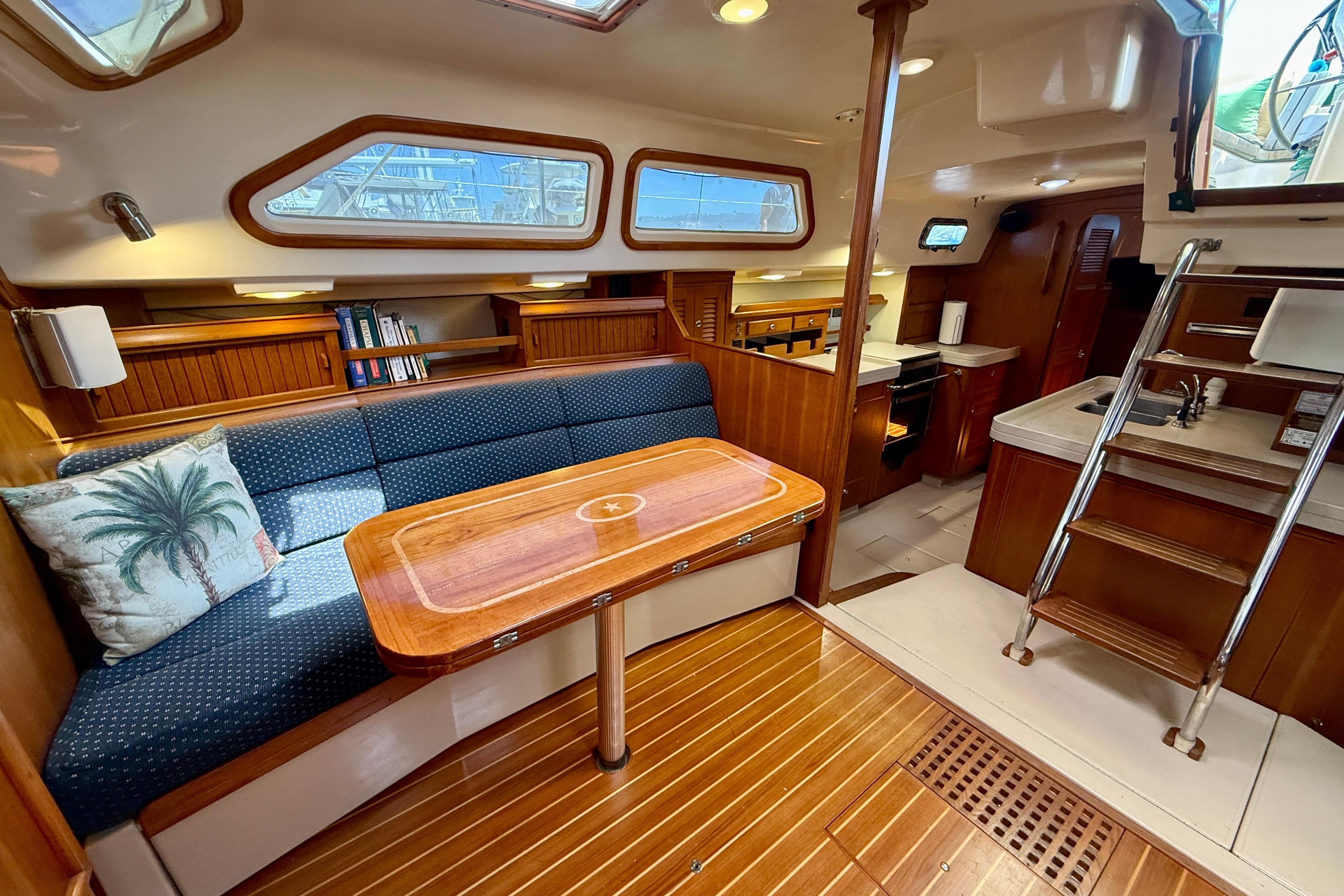 Interior of 2006 Island Packet 485 yacht with wooden finishes and cozy seating area.
