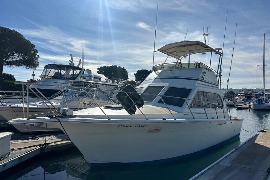 1985 Egg Harbor 33 Sedan yacht docked at marina under clear blue sky.