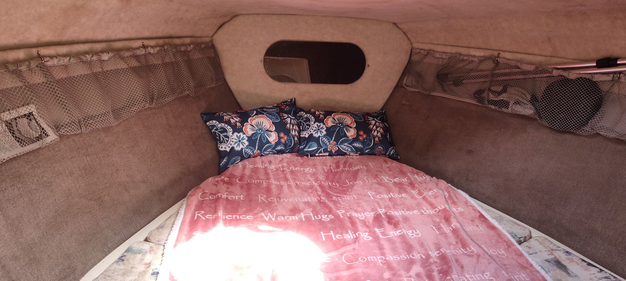 Interior of a 2002 Stingray 240 CR with a cozy bed and decorative pillows.