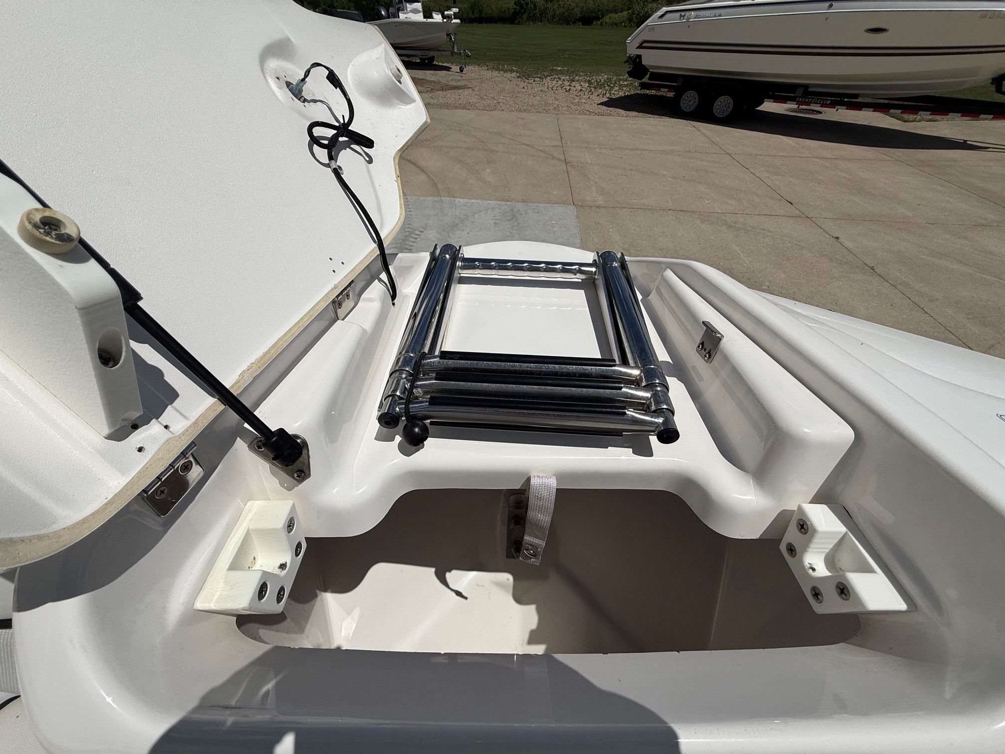 An open storage compartment on a Yamaha SX210 boat with a ladder.
