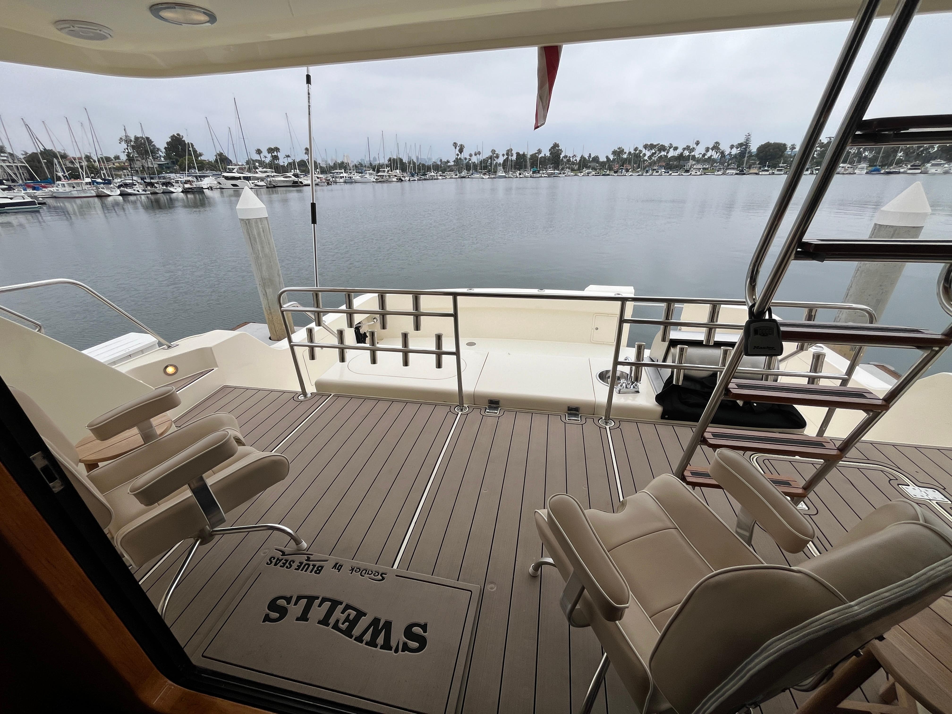 1999 Mikelson Long-Range Luxury Sportfisher deck with chairs, overlooking marina.