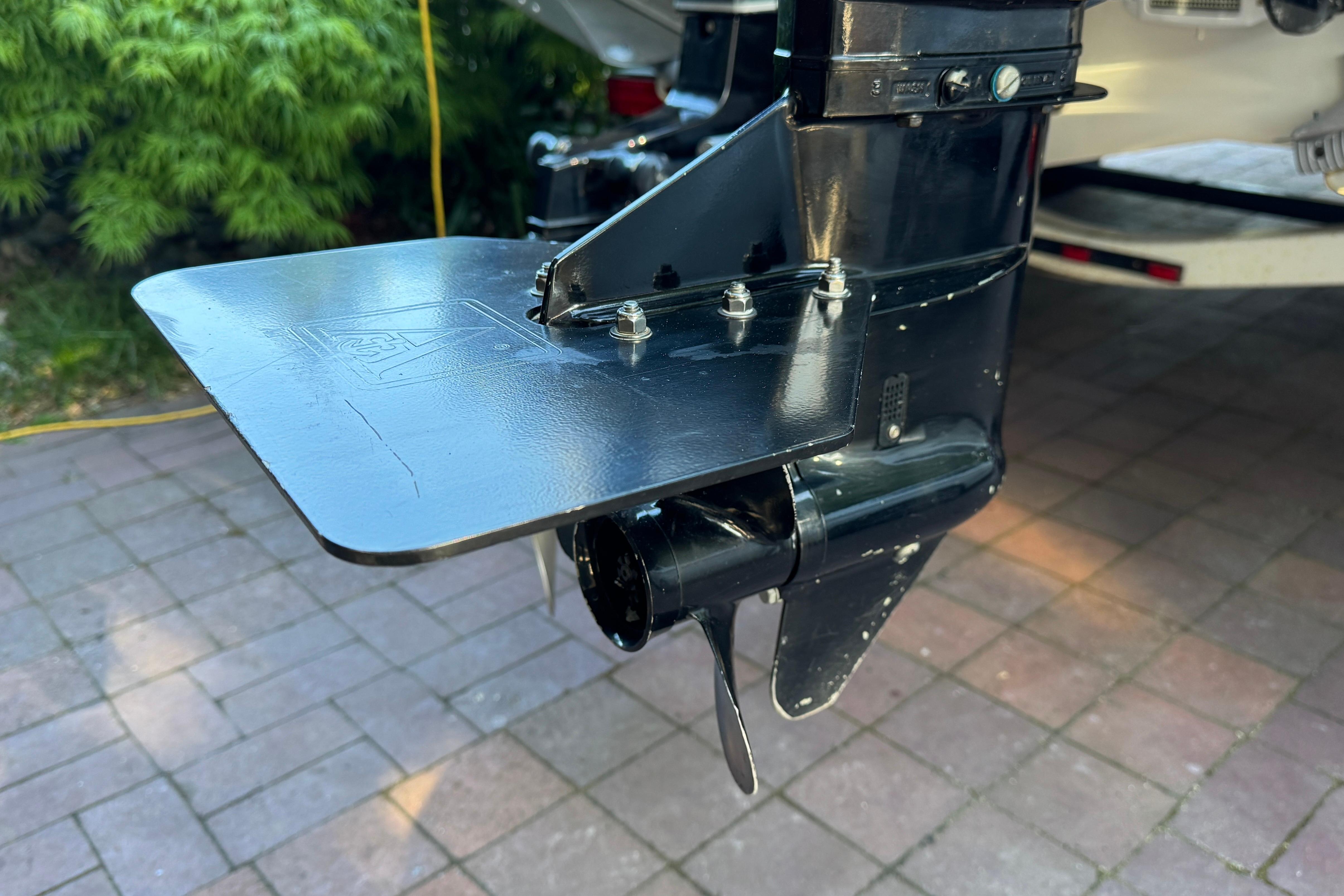 Close-up of a 2003 Malibu Sportster LX boat propeller and fin on a paved surface.