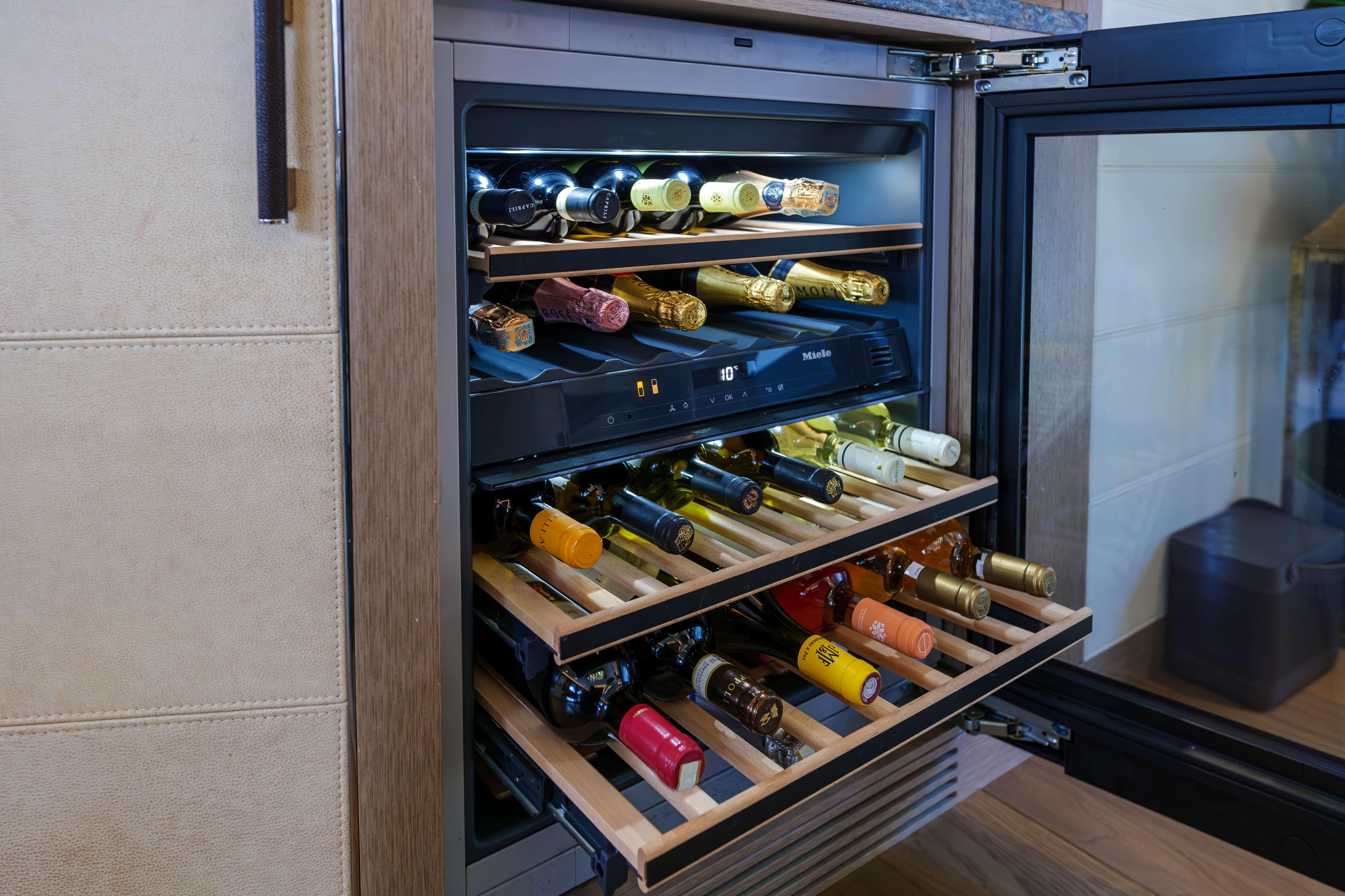 Wine cooler with wooden shelves in a 2024 Sirena 88 yacht interior.