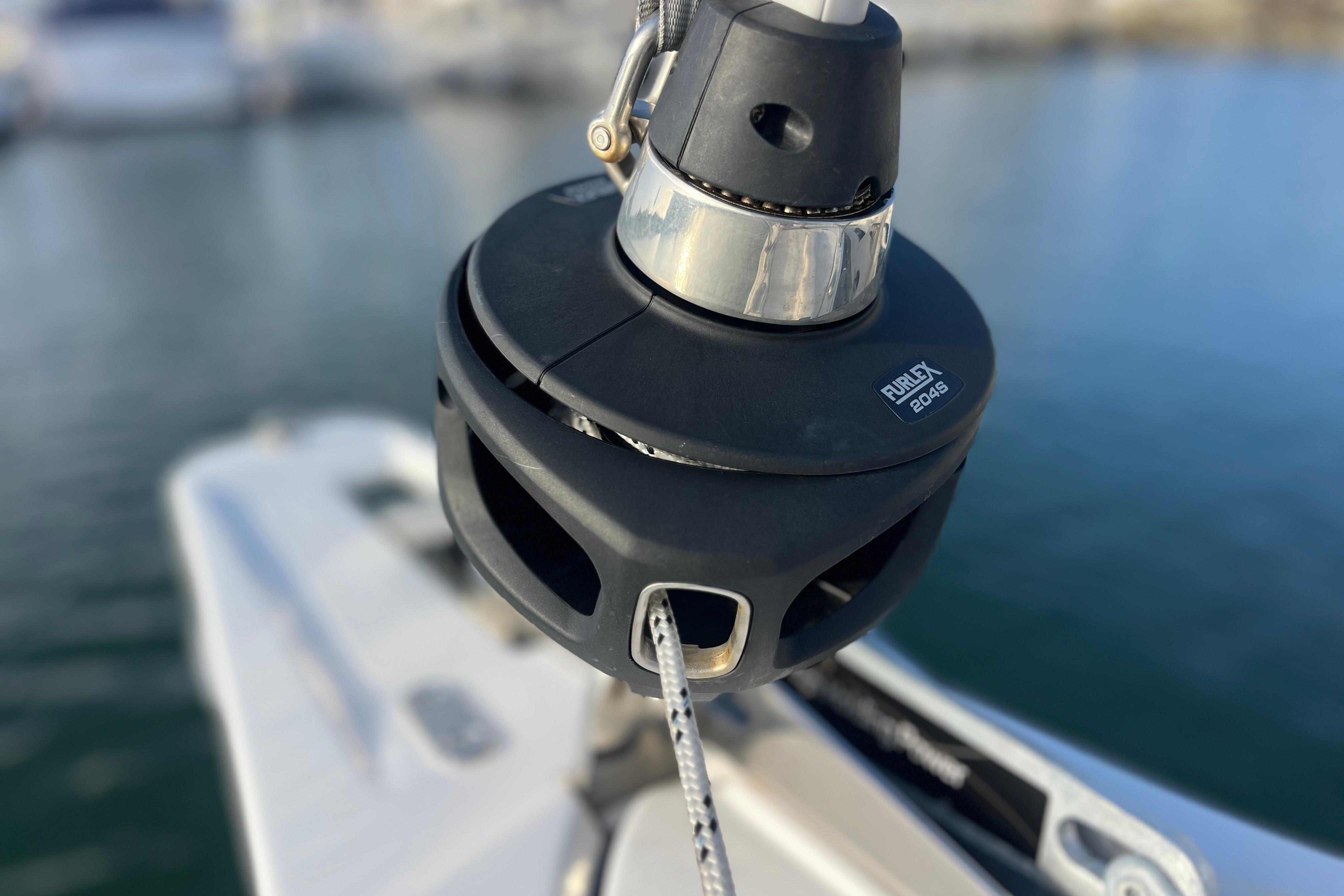 Close-up of a Hanse 360 sailboat's furling system, 2025 model, on calm water.