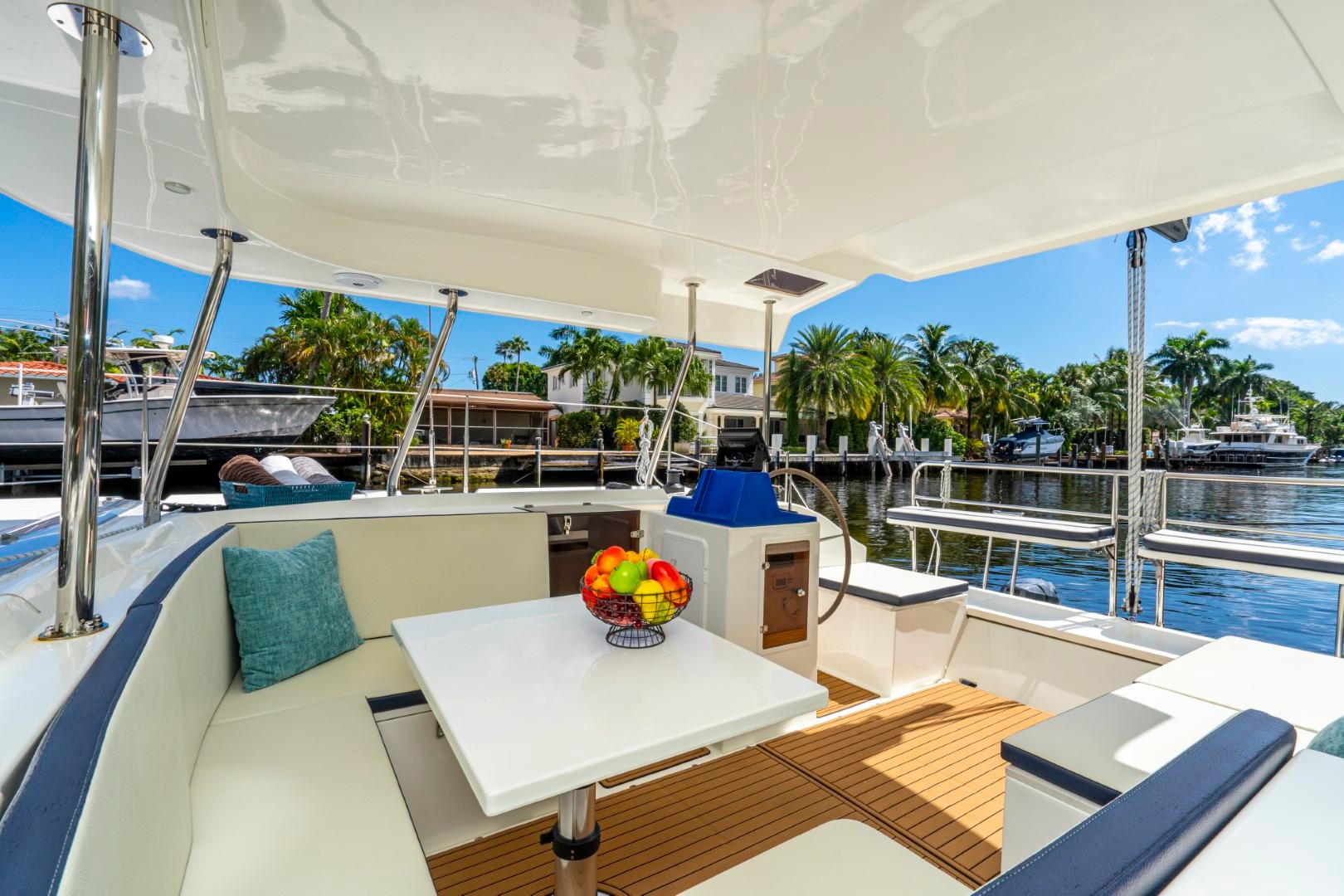 Luxurious 2025 Smart Cat S280 yacht interior with seating, table, and waterfront view.