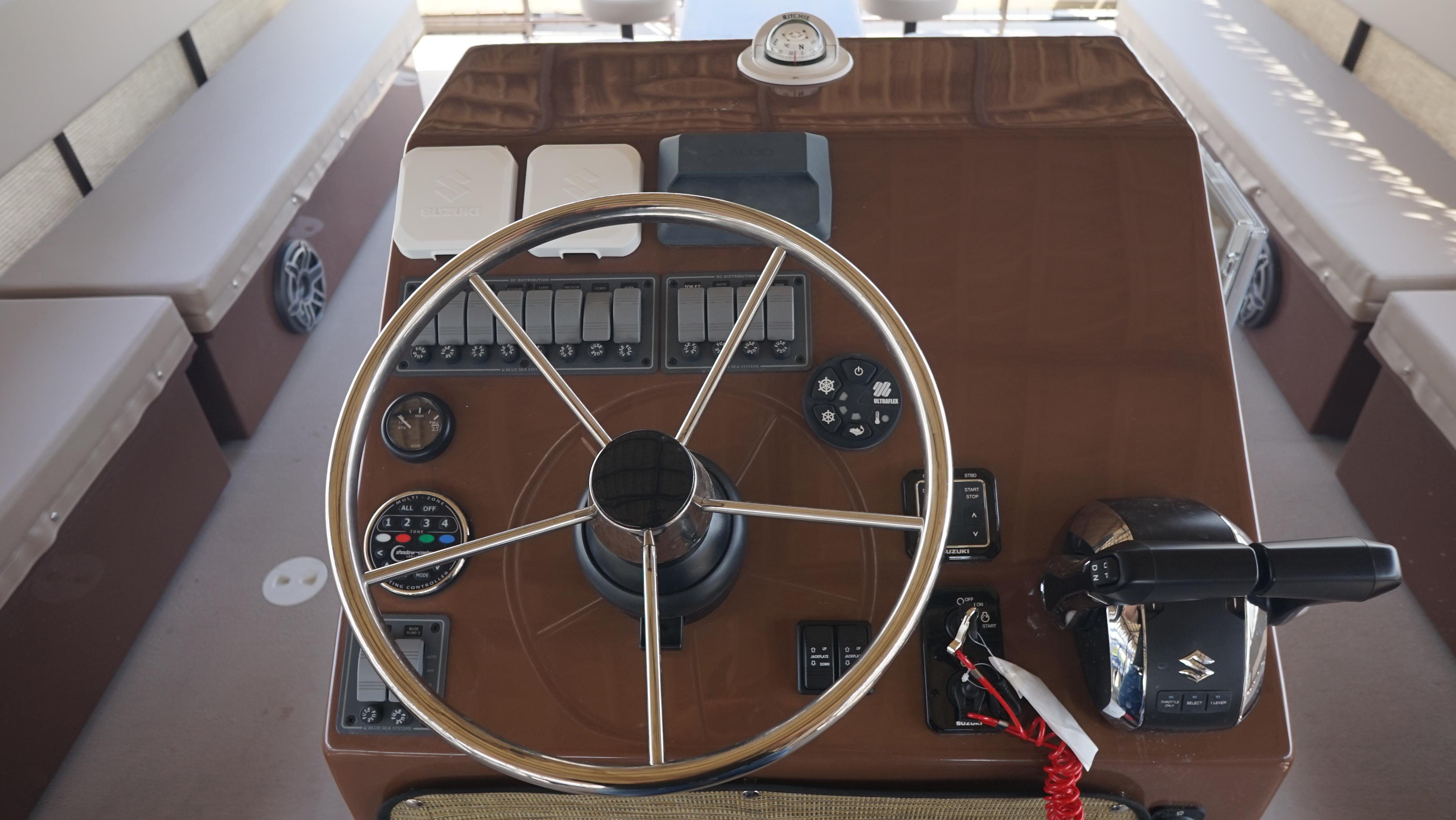 2024 A&M Manufacturing BullDog 34 boat helm with steering wheel and controls.