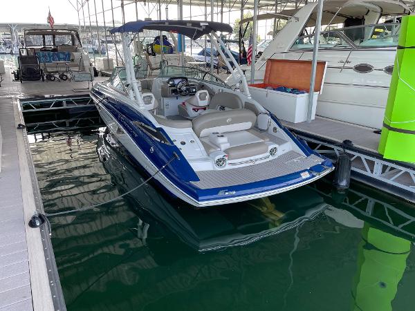 2019 Crownline E255 boat docked in a marina, featuring a sleek blue and white design.