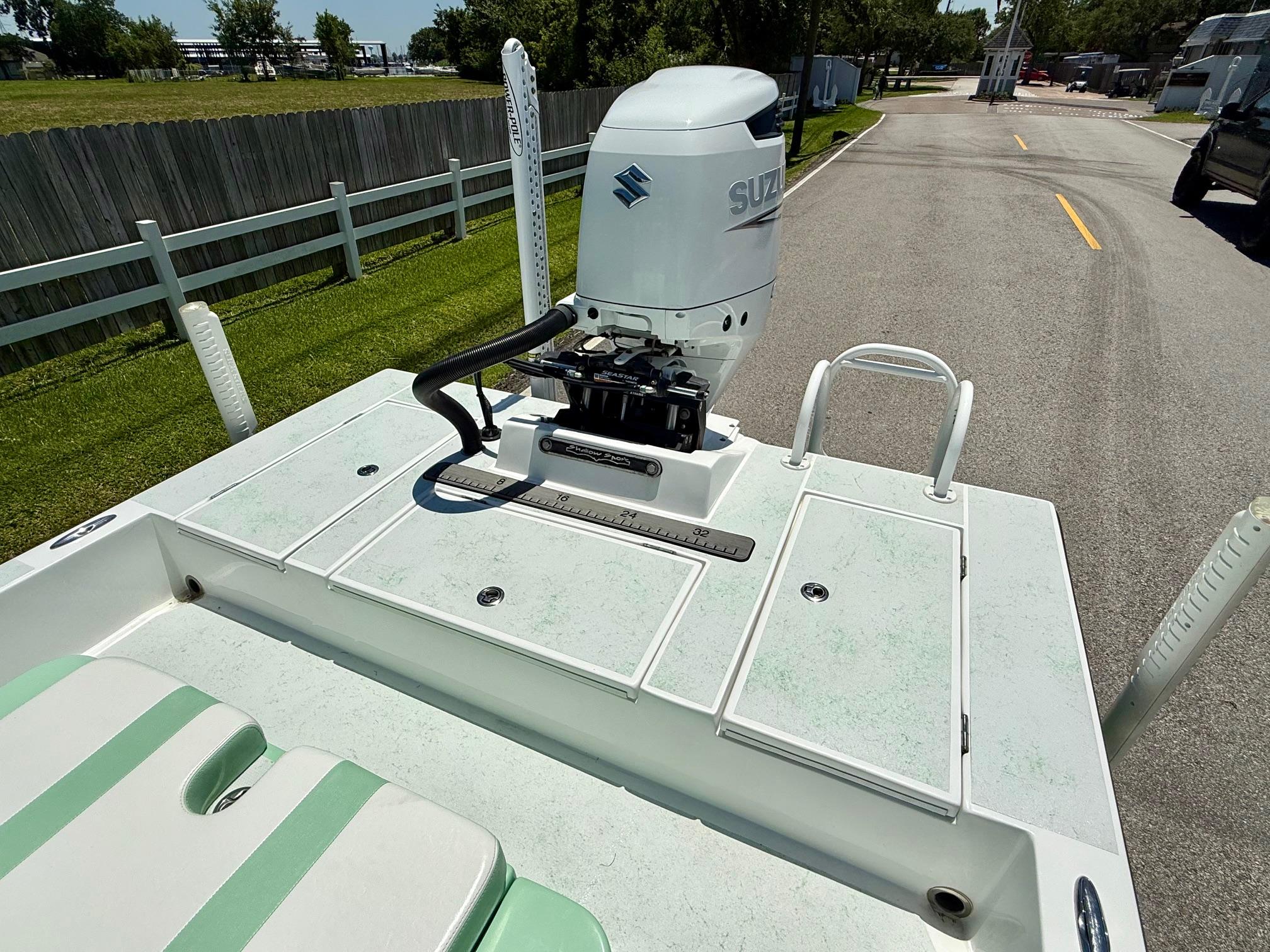 2023 Shallow Sport 24 Sport boat with Suzuki outboard motor on a sunny day.