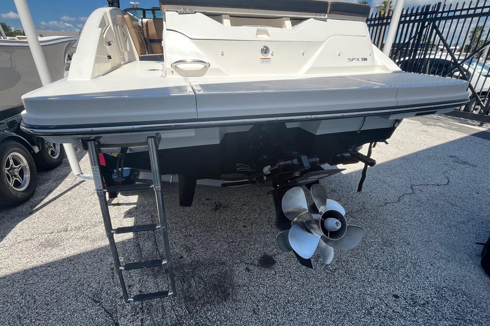 2024 Sea Ray SPX 230 boat rear view with propeller and swim ladder.