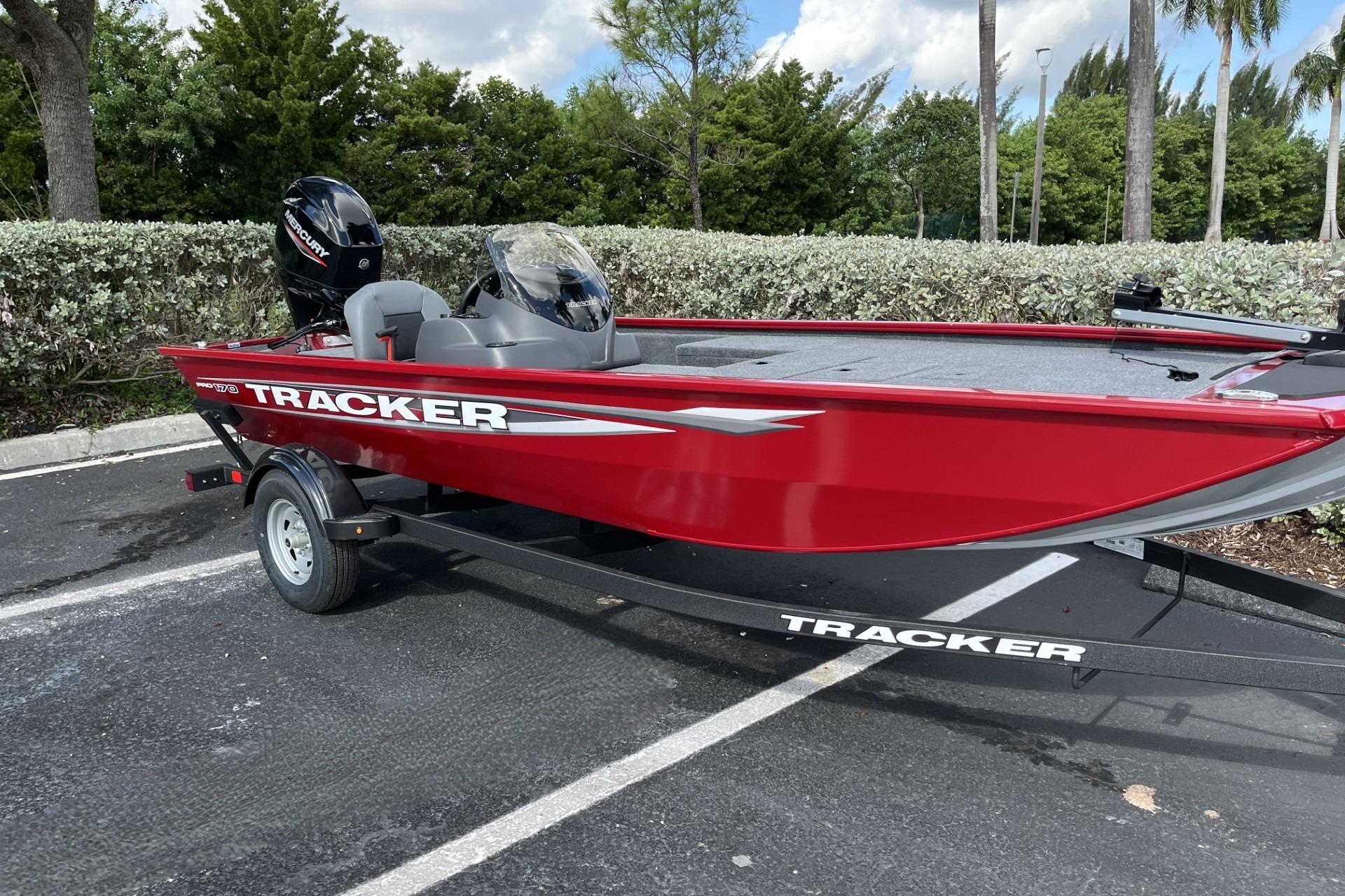 2026 Tracker Pro 170 boat in vibrant red, parked on a trailer in a scenic outdoor setting.