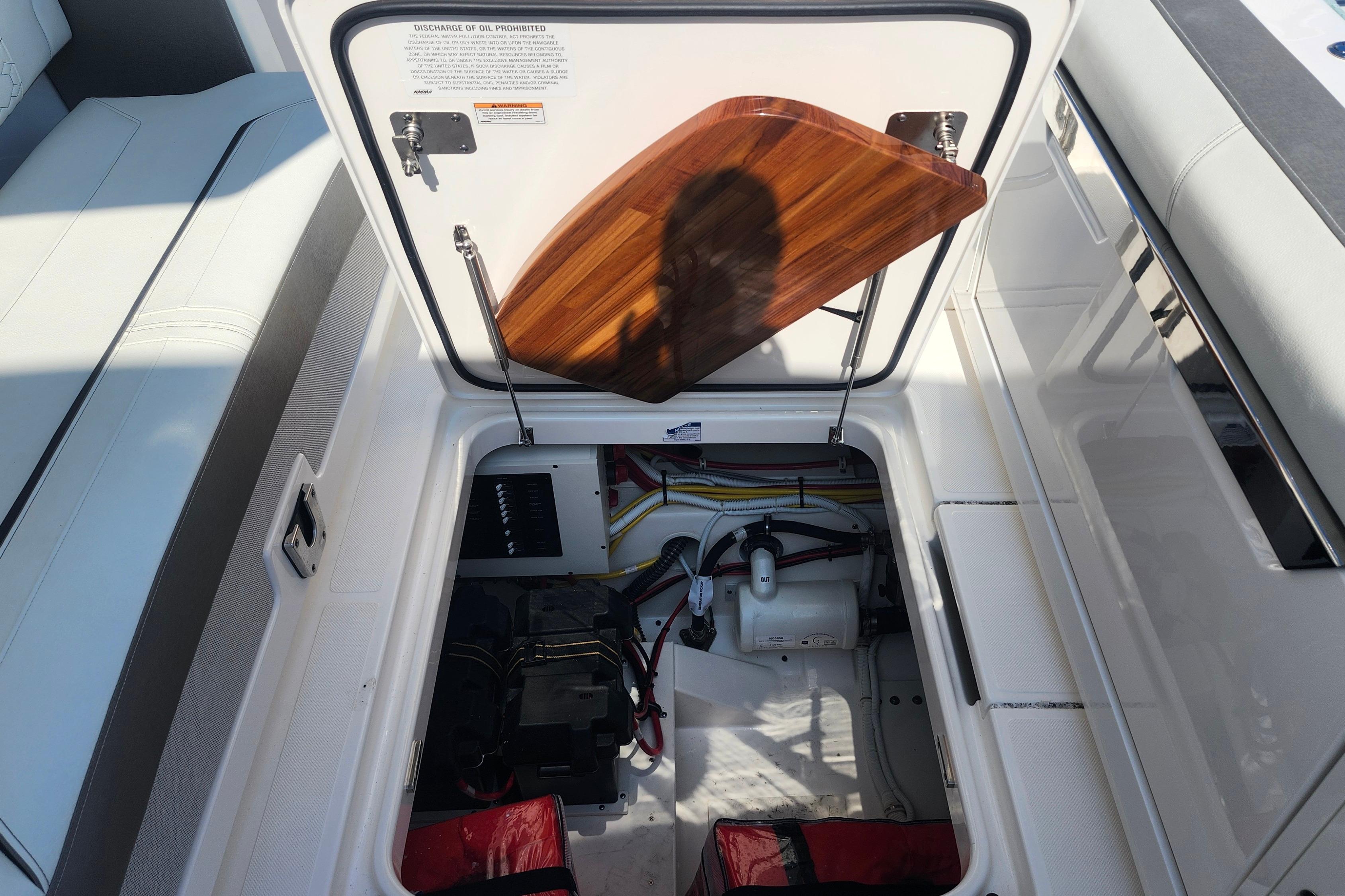 Open hatch of 2024 Tiara Yachts 34 LS, revealing engine compartment and wiring.