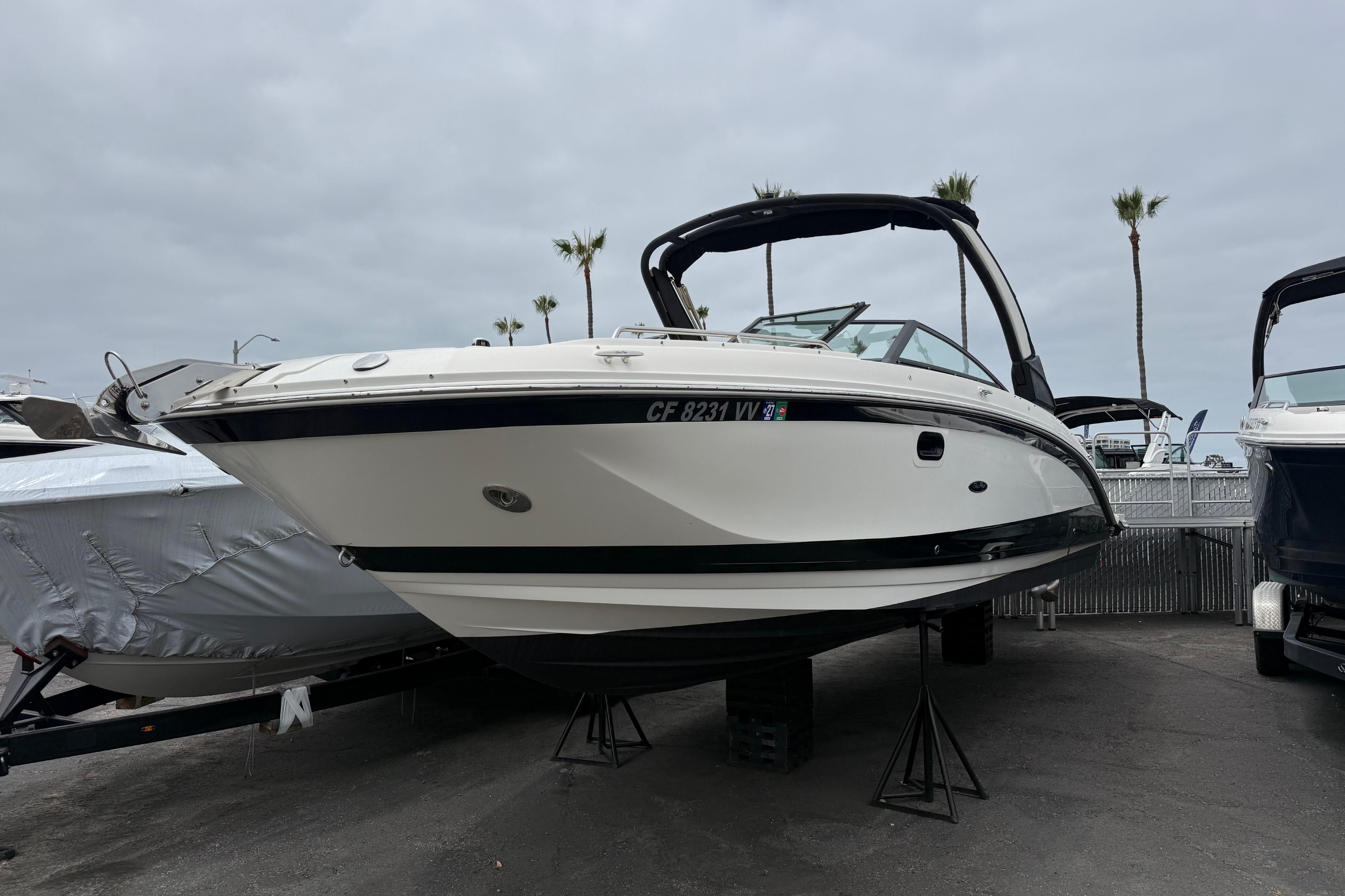 2022 Sea Ray SDX 290 Outboard boat displayed on stands, with palm trees in the background.