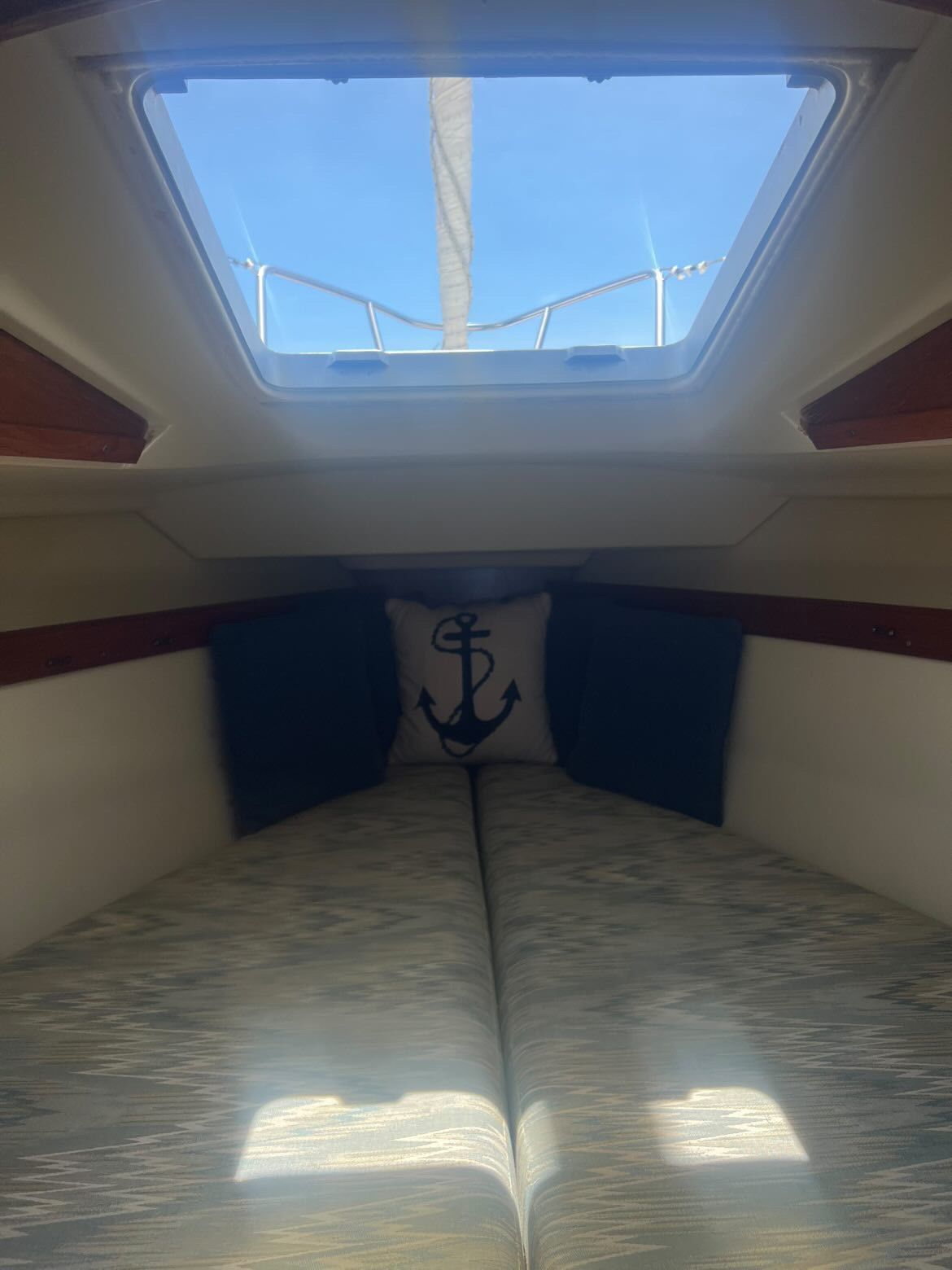Interior of a 1988 Pearson 28 with an anchor pillow and blue cushions.