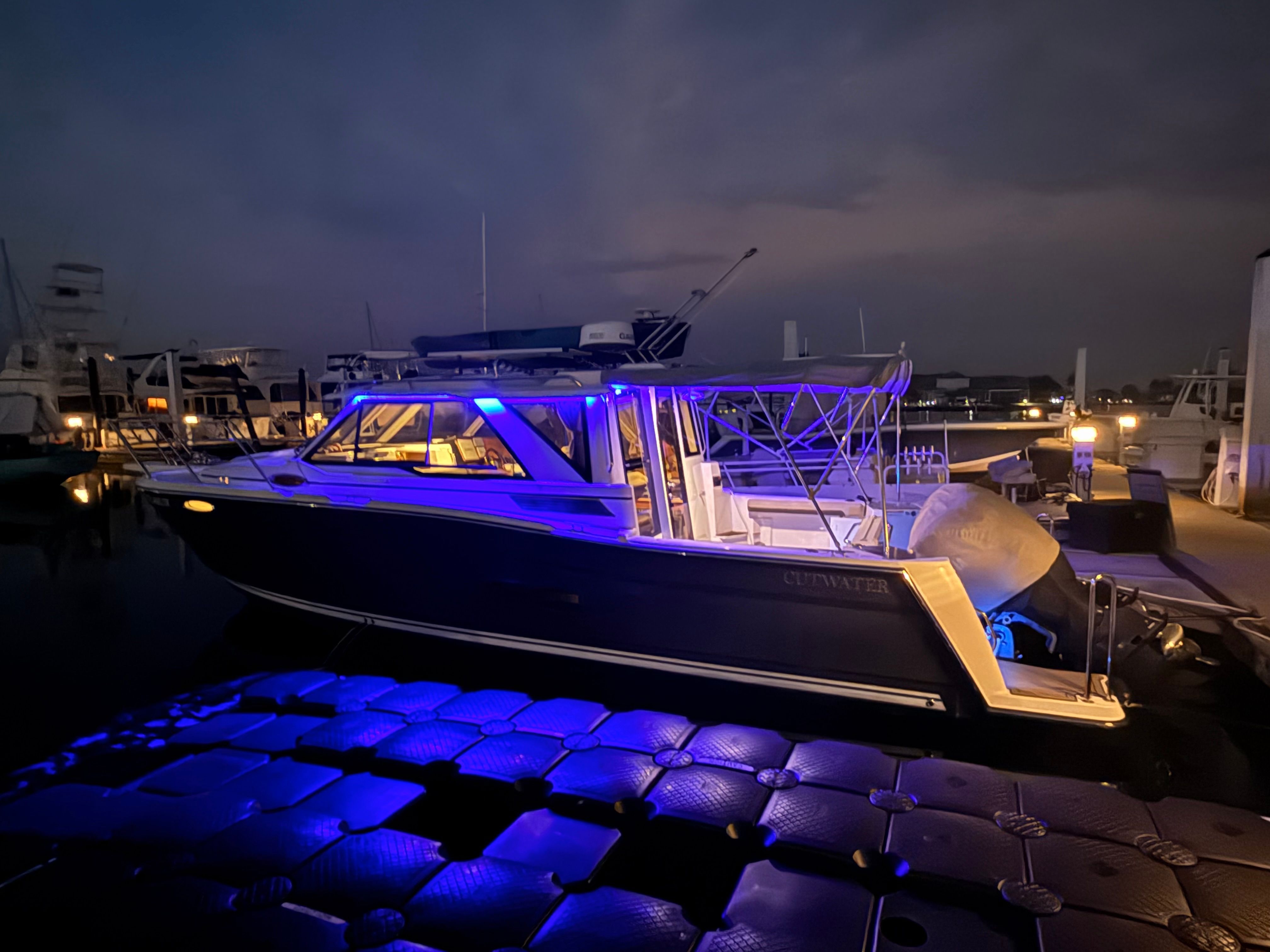 2023 Cutwater C-228 at night with blue lighting at the dock.
