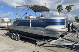 2023 Suntracker G3 Select 322 CC pontoon boat on trailer, parked outdoors.