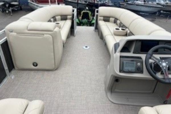 2024 Sun Tracker Party Barge 24 DLX interior with beige seating and modern dashboard.