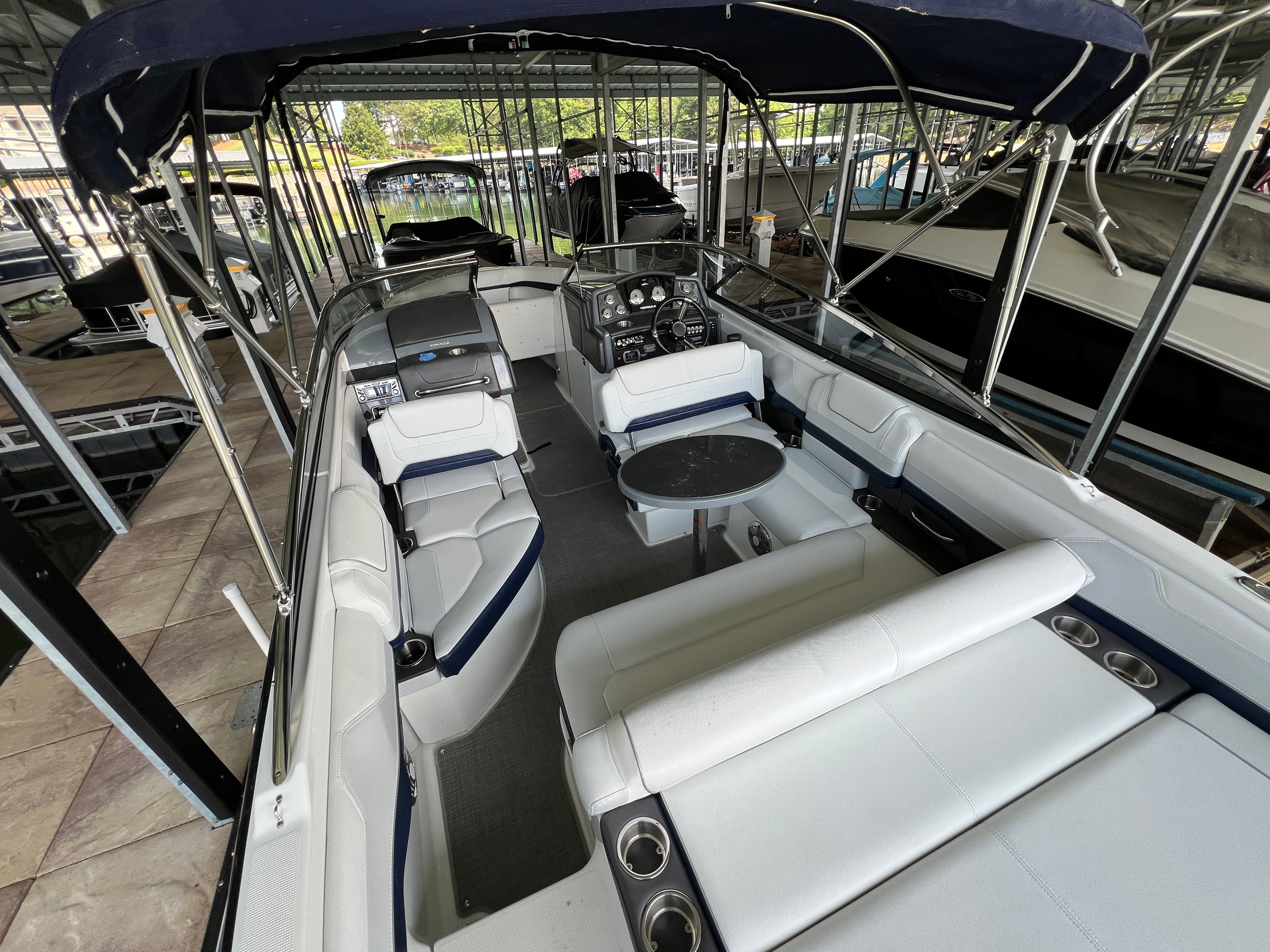 A modern boat interior with white seating and a small table.