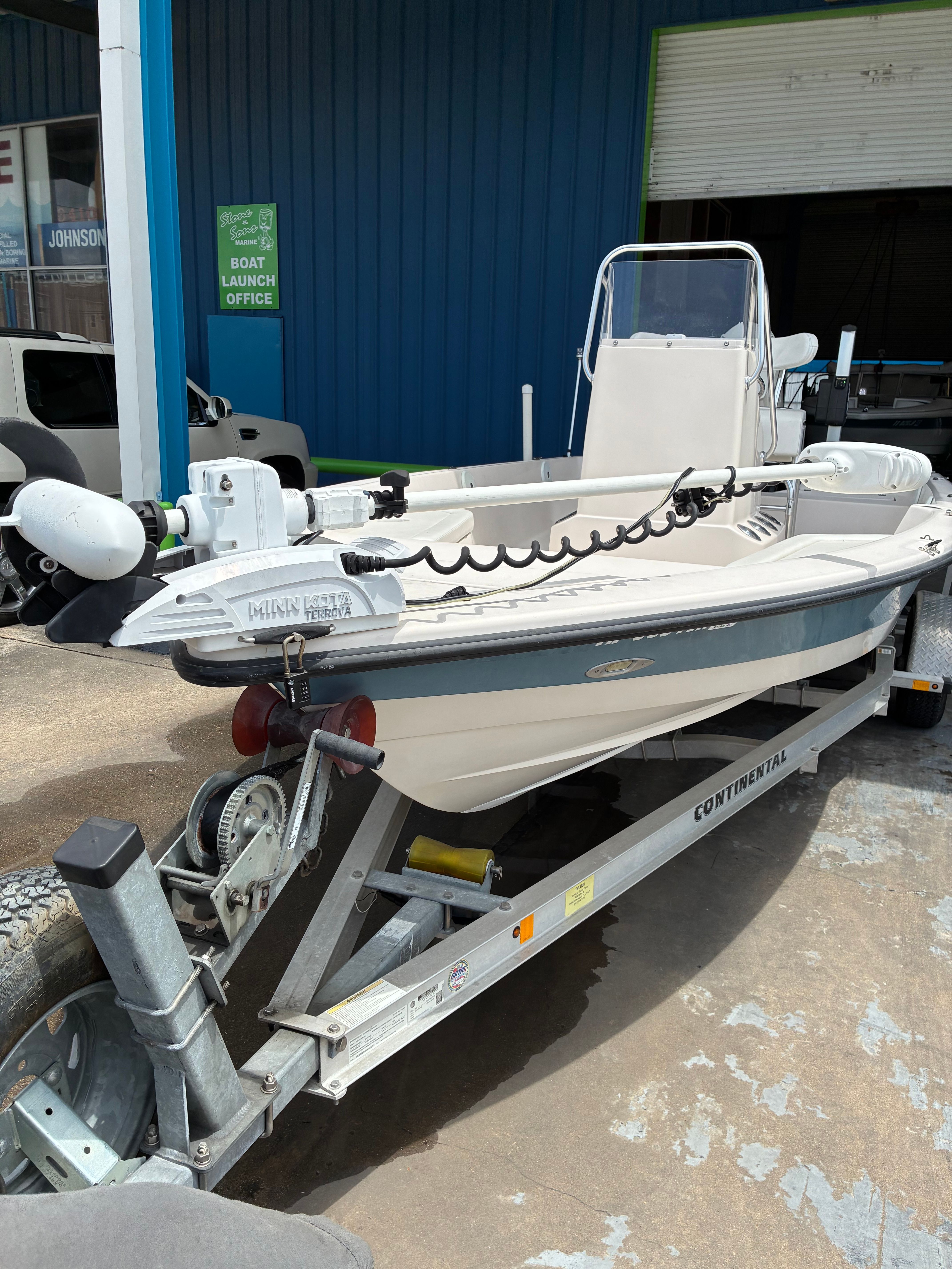 2016 Pathfinder Fishing boat on trailer outside blue building.
