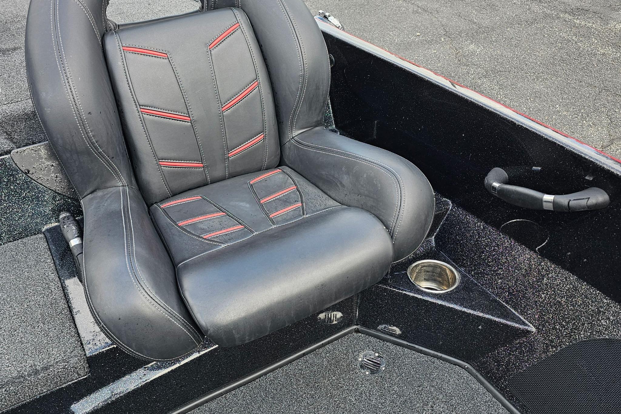 Black and red seat in a 2017 Nitro Z20 Pro boat, featuring cup holder and textured flooring.