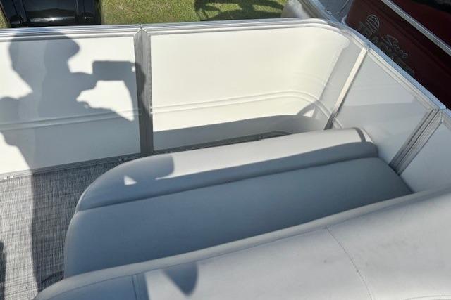 2026 Sun Tracker Party Barge 18 DLX interior with white seating and shadow on deck.