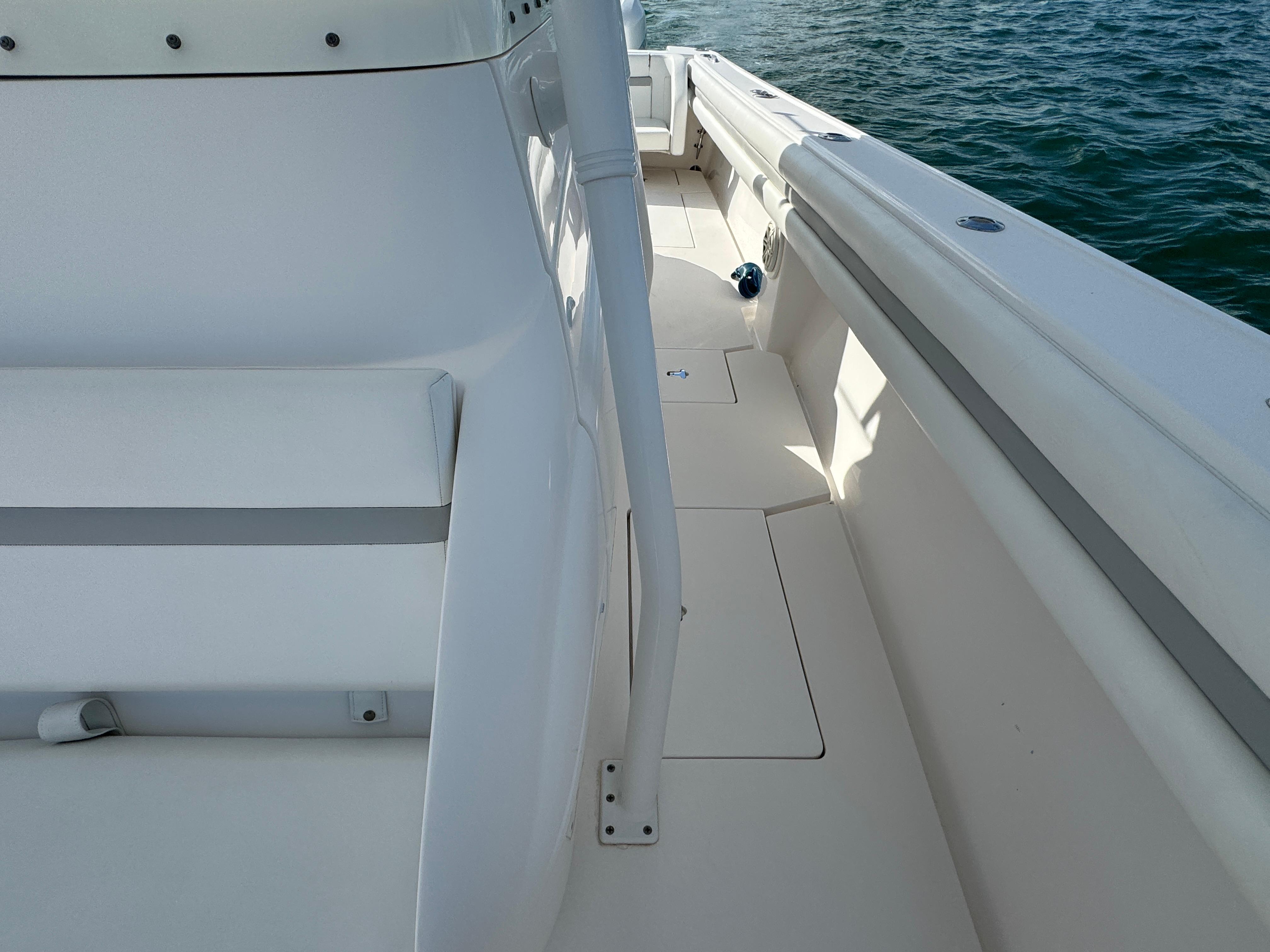 2016 Intrepid 375 CC boat deck with white seating and railing, on calm water.