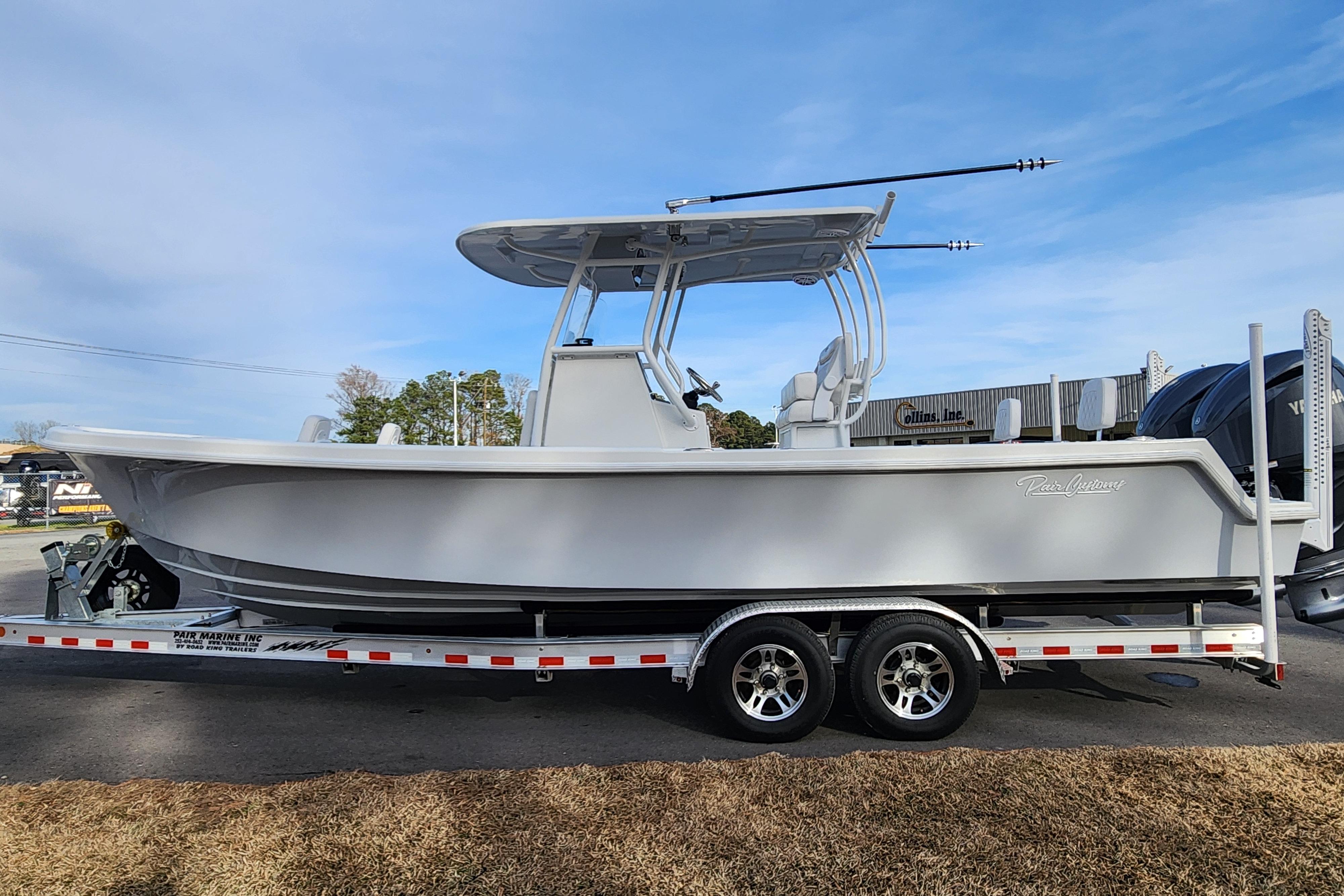 2024 Pair Customs 27 CC boat on trailer, side view, outdoors.