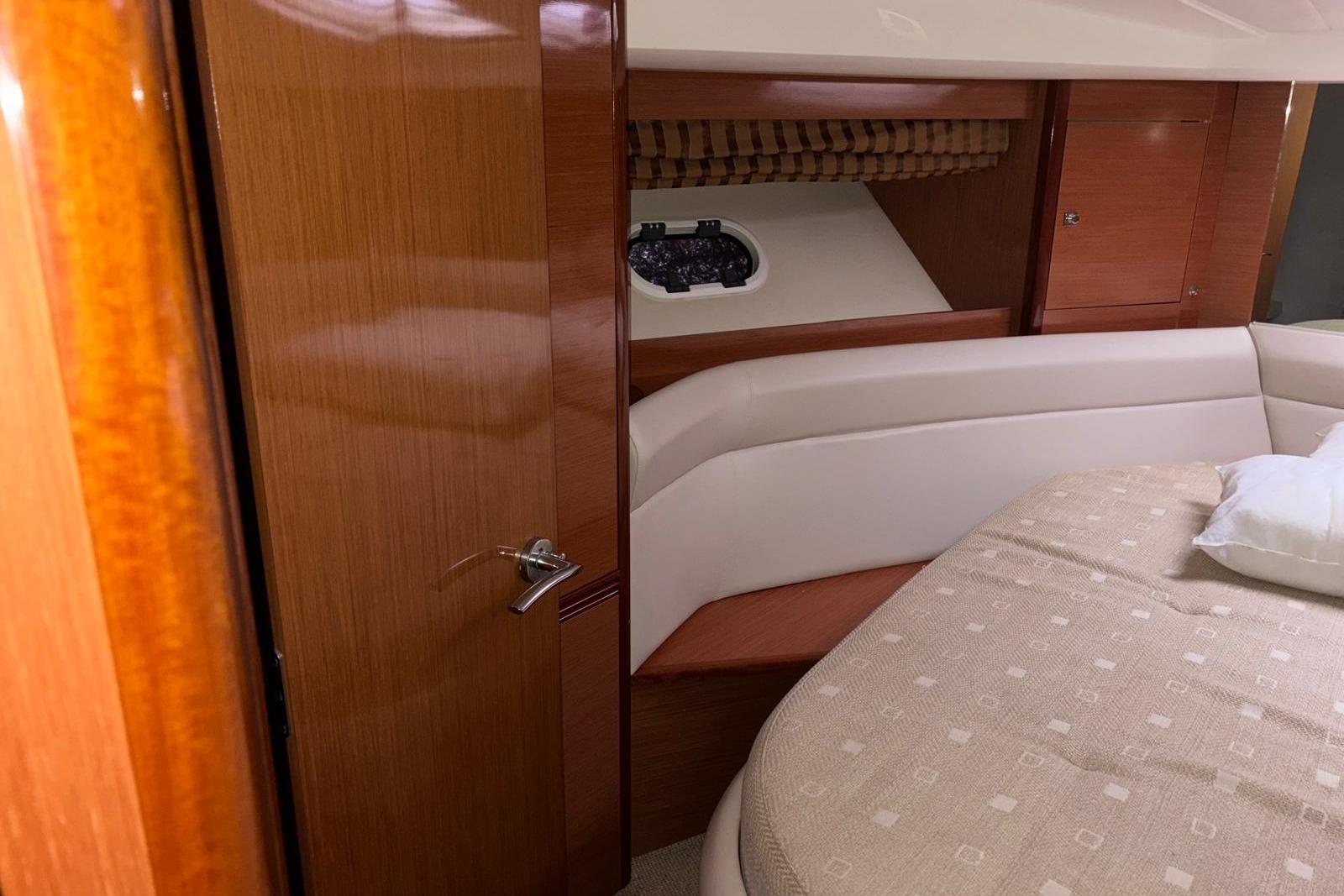 Interior of 2009 Jeanneau Prestige 42 S yacht with wooden cabinetry and cozy bed.