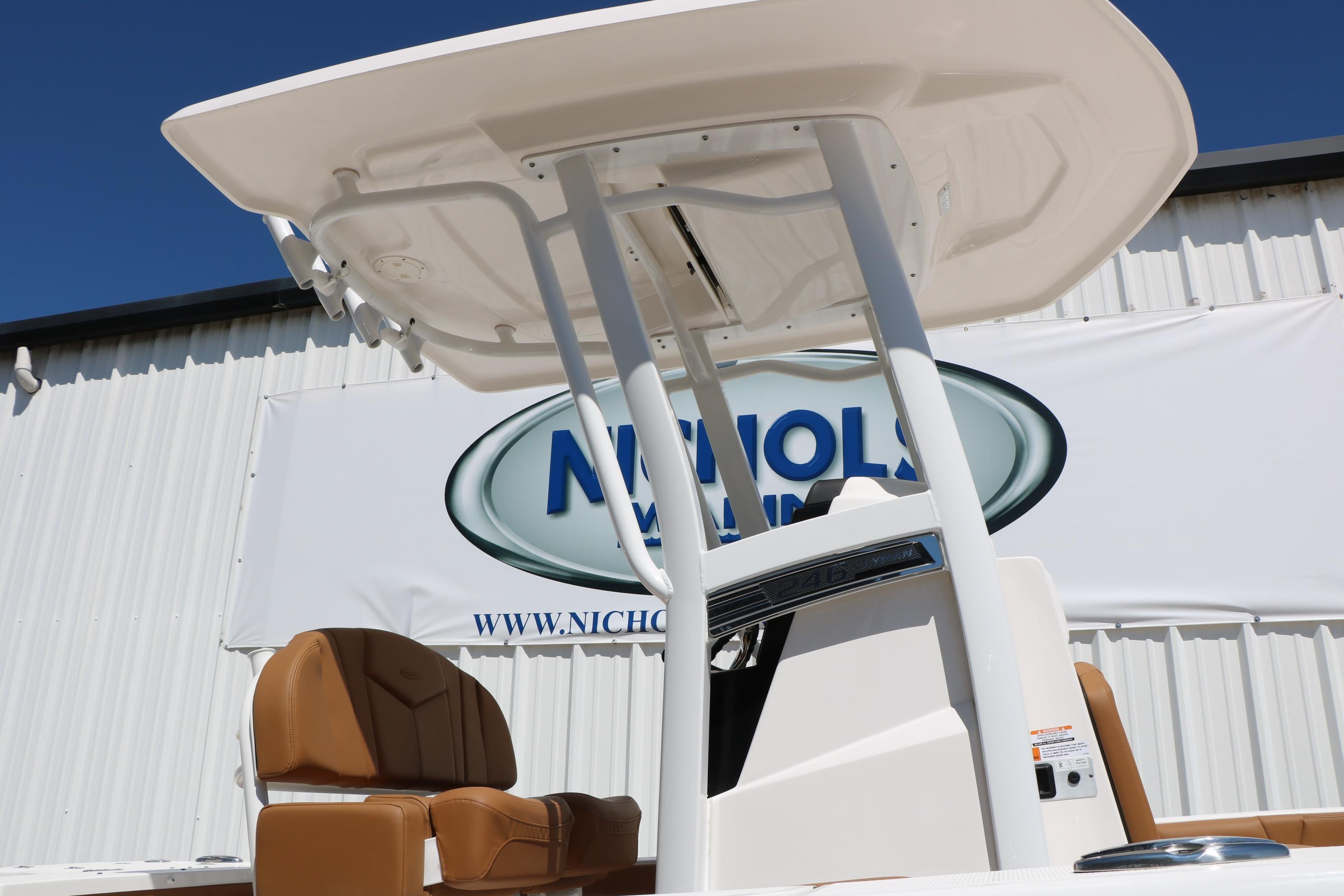 2026 Robalo 246 Cayman boat with T-top and tan seating, displayed outdoors.