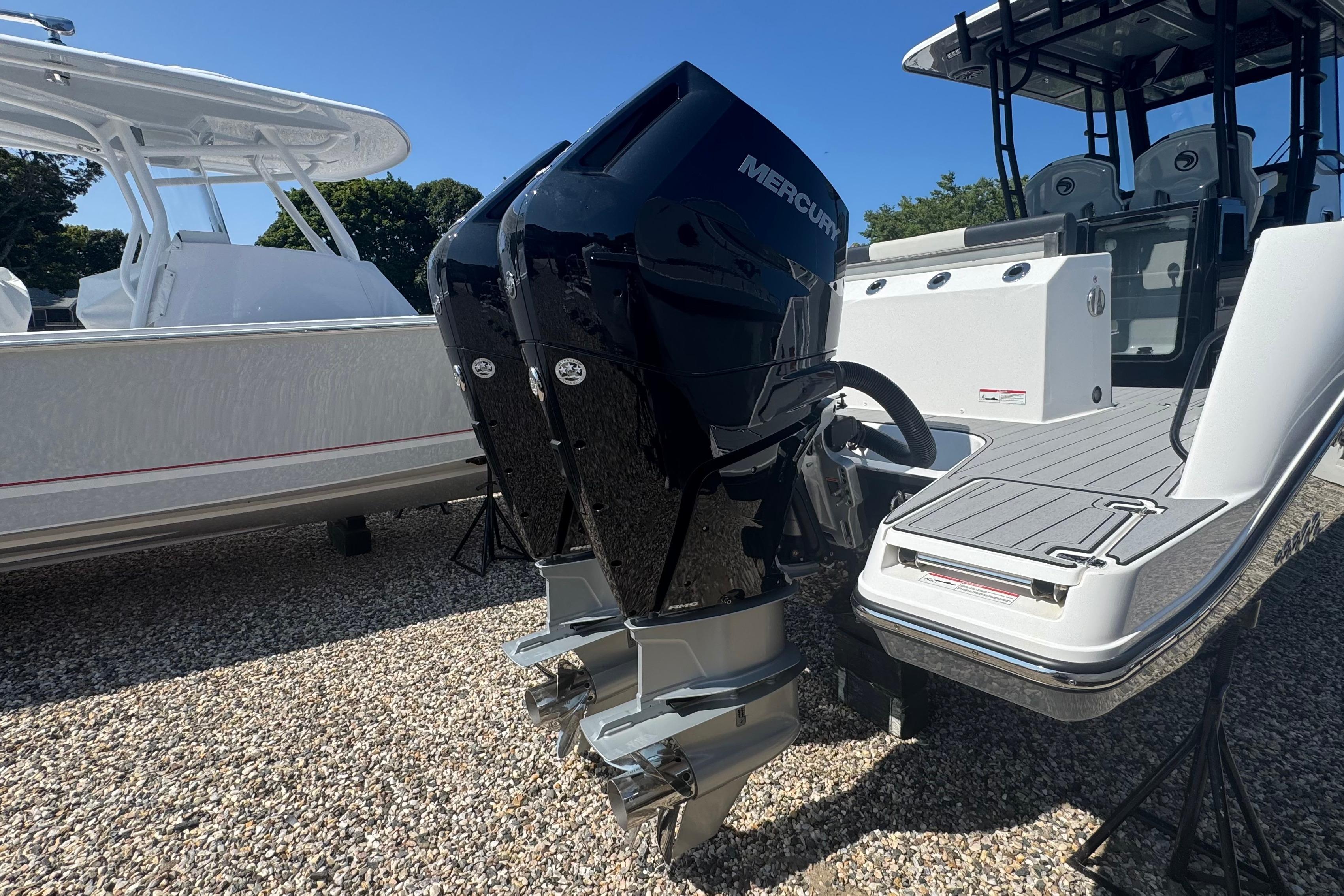 2025 Edgewater 340CC boat with dual Mercury outboard engines on display.