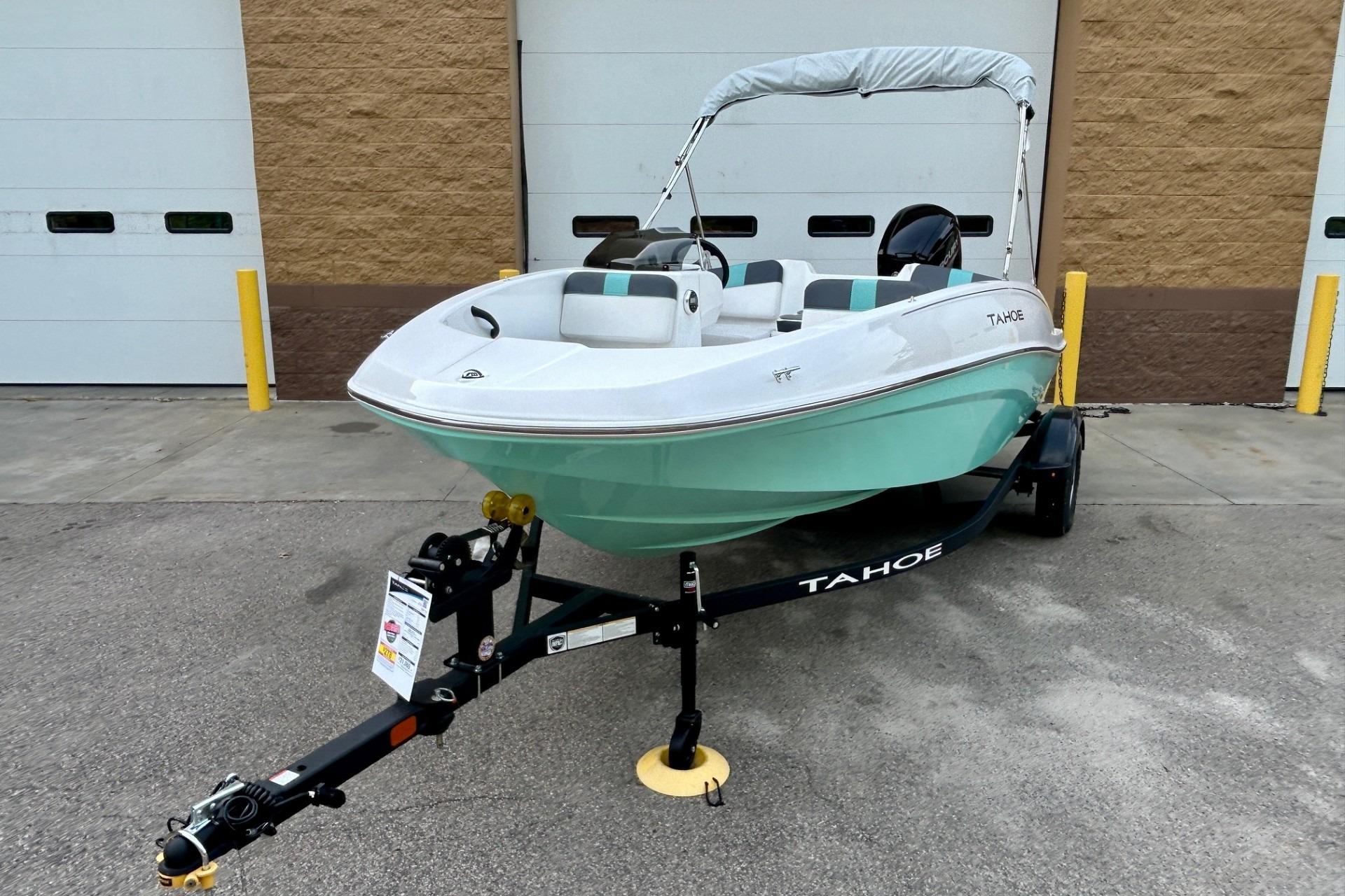 2026 Tahoe T16 boat on trailer, parked outside a garage.