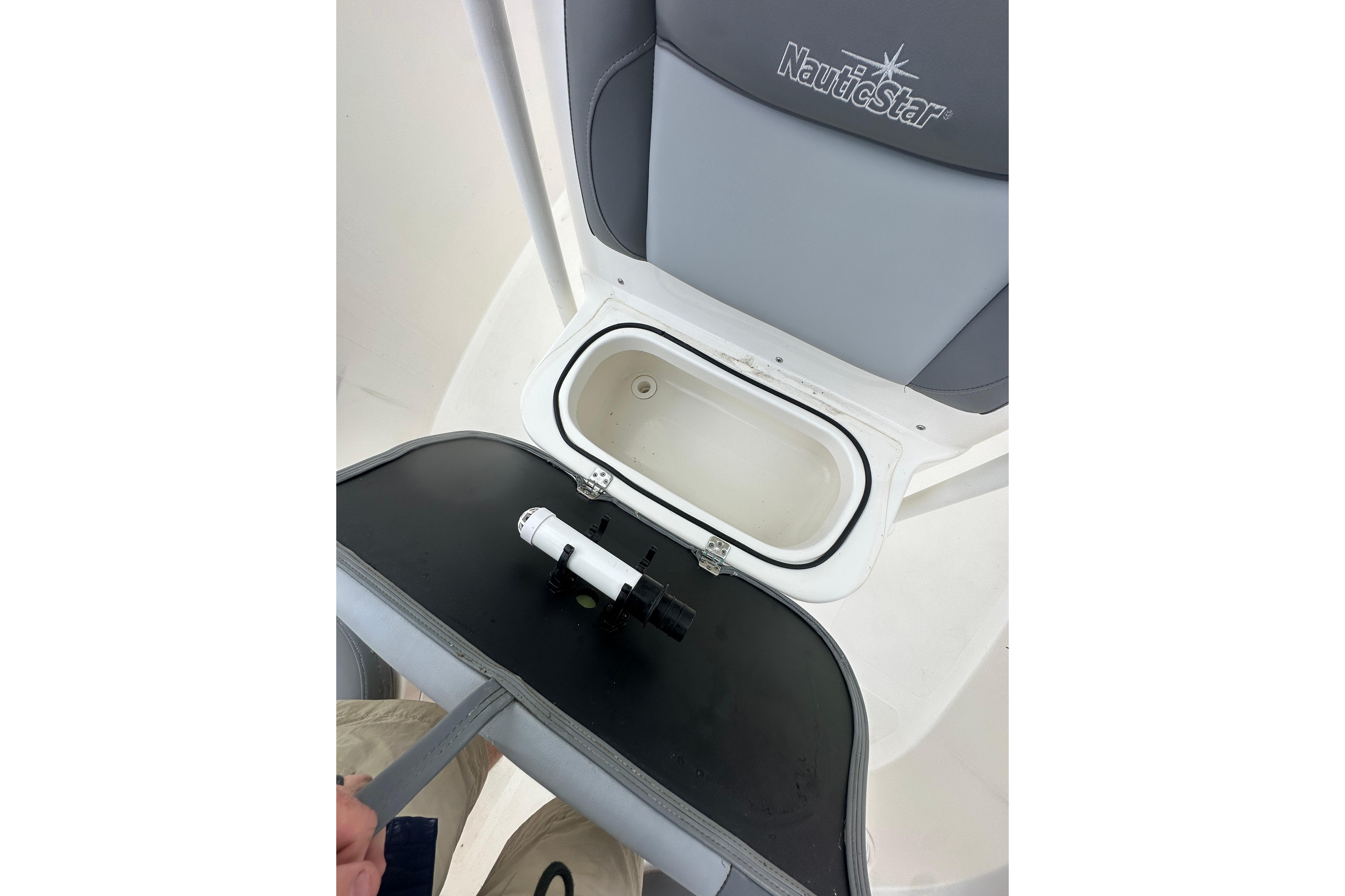 2023 NauticStar 2102 Legacy boat seat with storage compartment open.