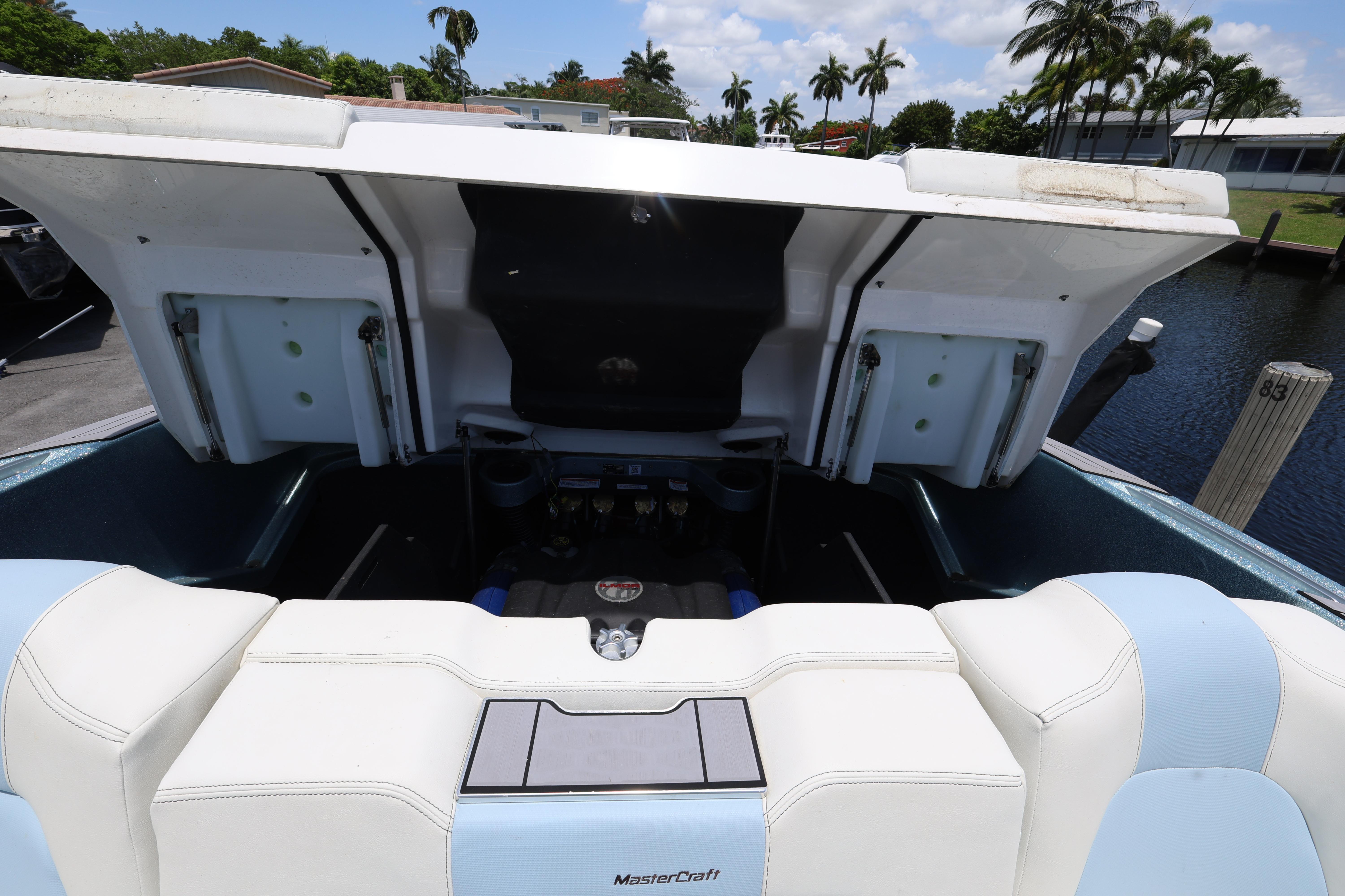 2023 MasterCraft X24 boat engine compartment with open hatch, dockside view.