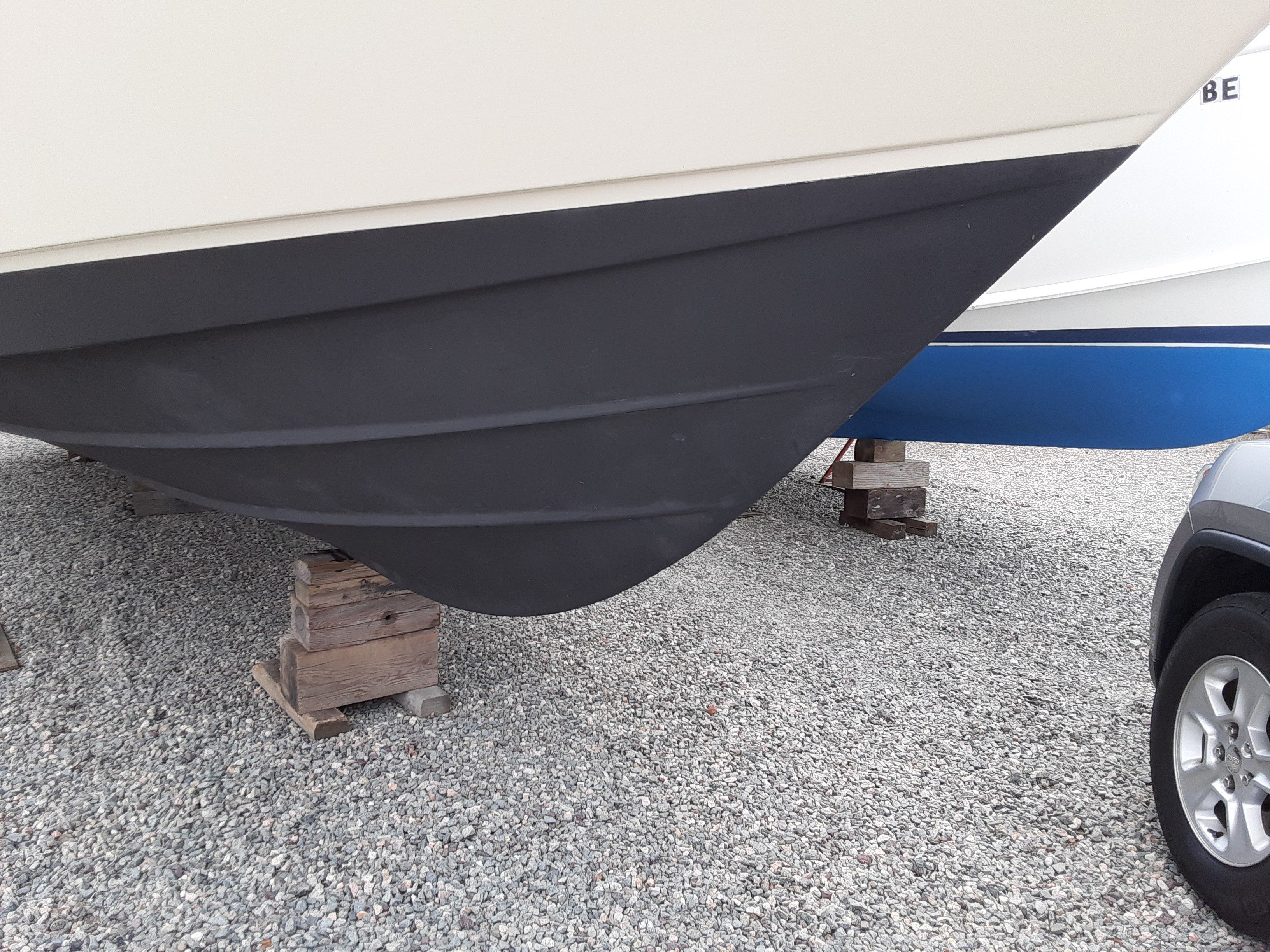 Hull of a 1985 Tiara Yachts 3100 Open on wooden blocks.