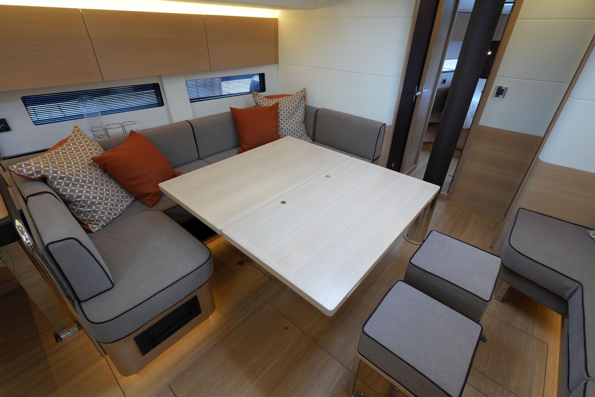 Luxurious interior of 2020 Amel 50 yacht with modern seating and dining area.