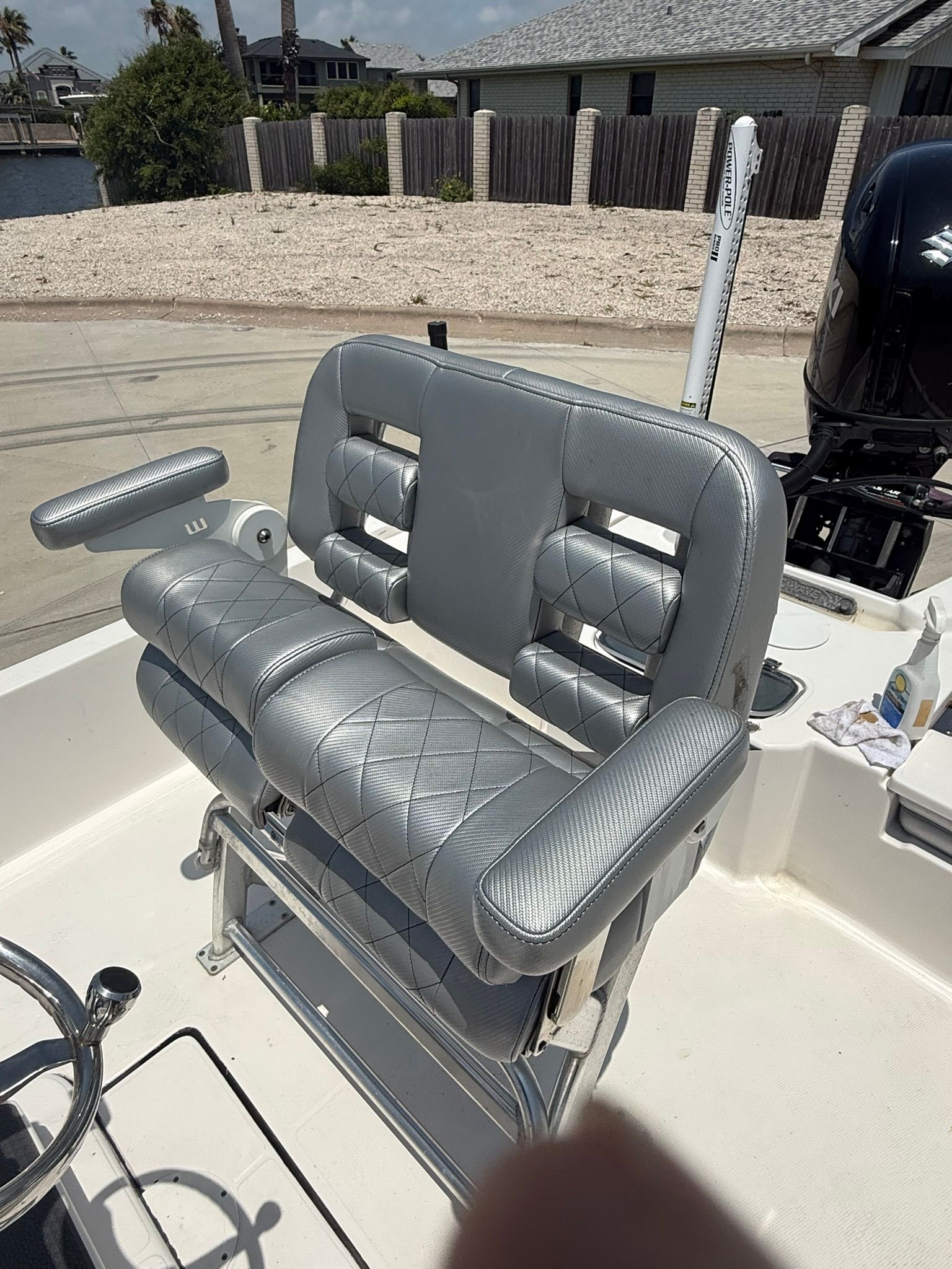 The image shows a cushioned bench seat on a boat, with gray leather and quilted pattern.