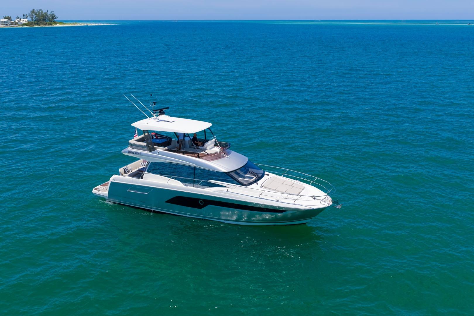 Luxury 2022 Prestige 520 yacht cruising on clear blue ocean waters.