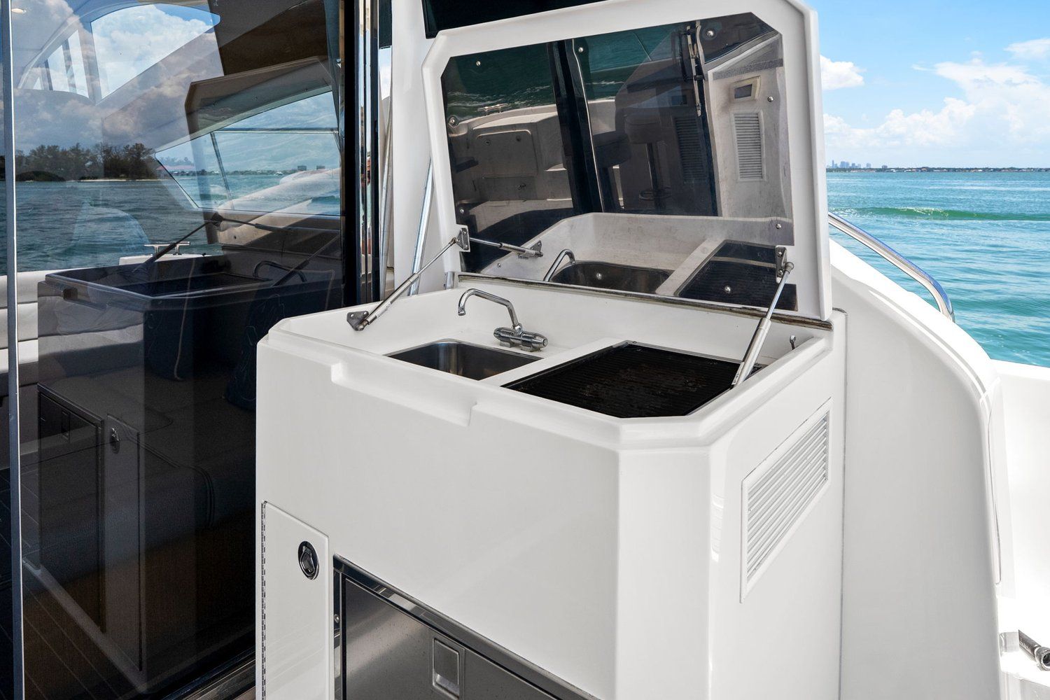 The 2018 Mym/Mares 47 Outboard Express Catamaran features an outdoor kitchenette with a sink and storage.