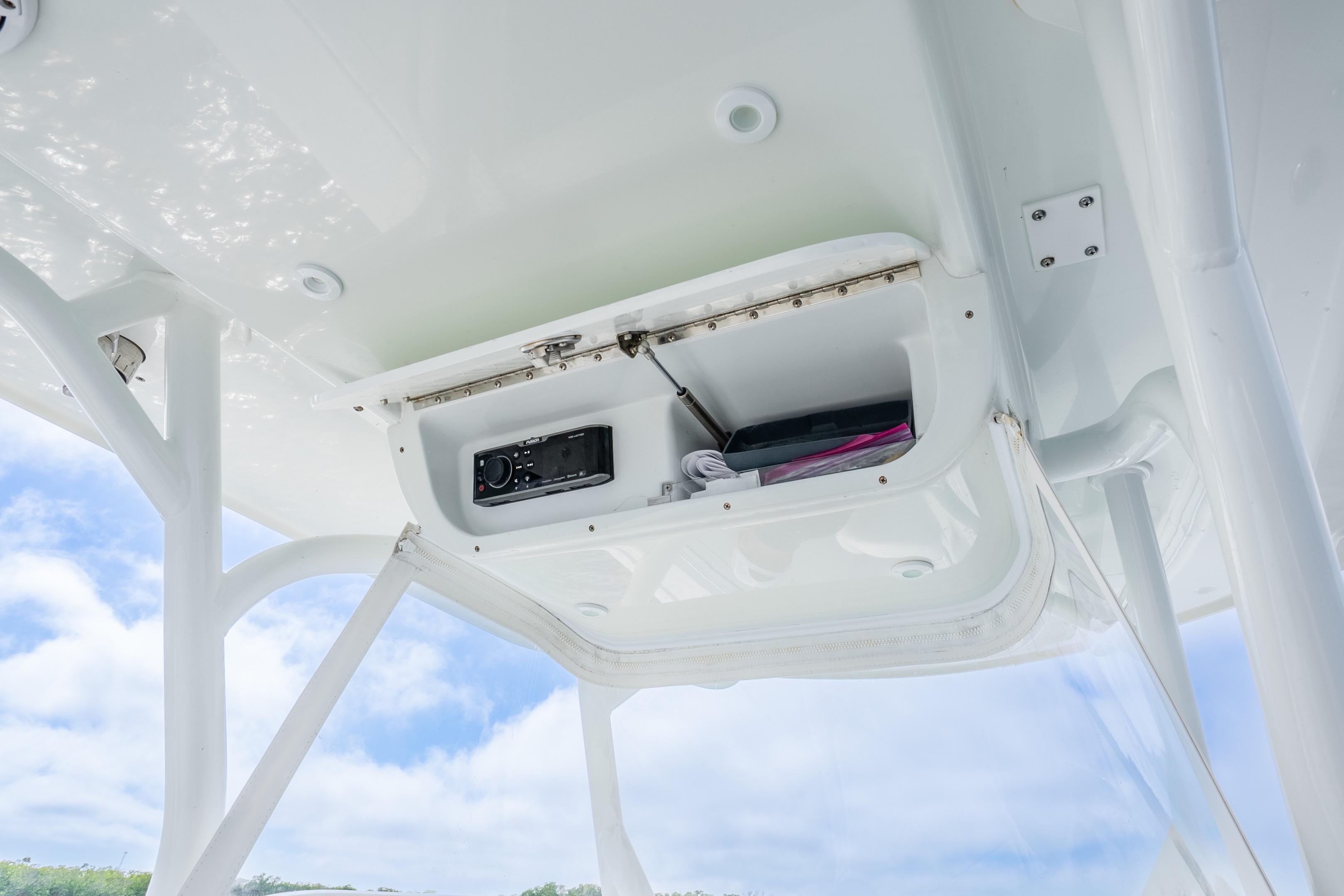 2016 Yellowfin 36 Offshore boat storage compartment with electronic equipment, under a clear blue sky.