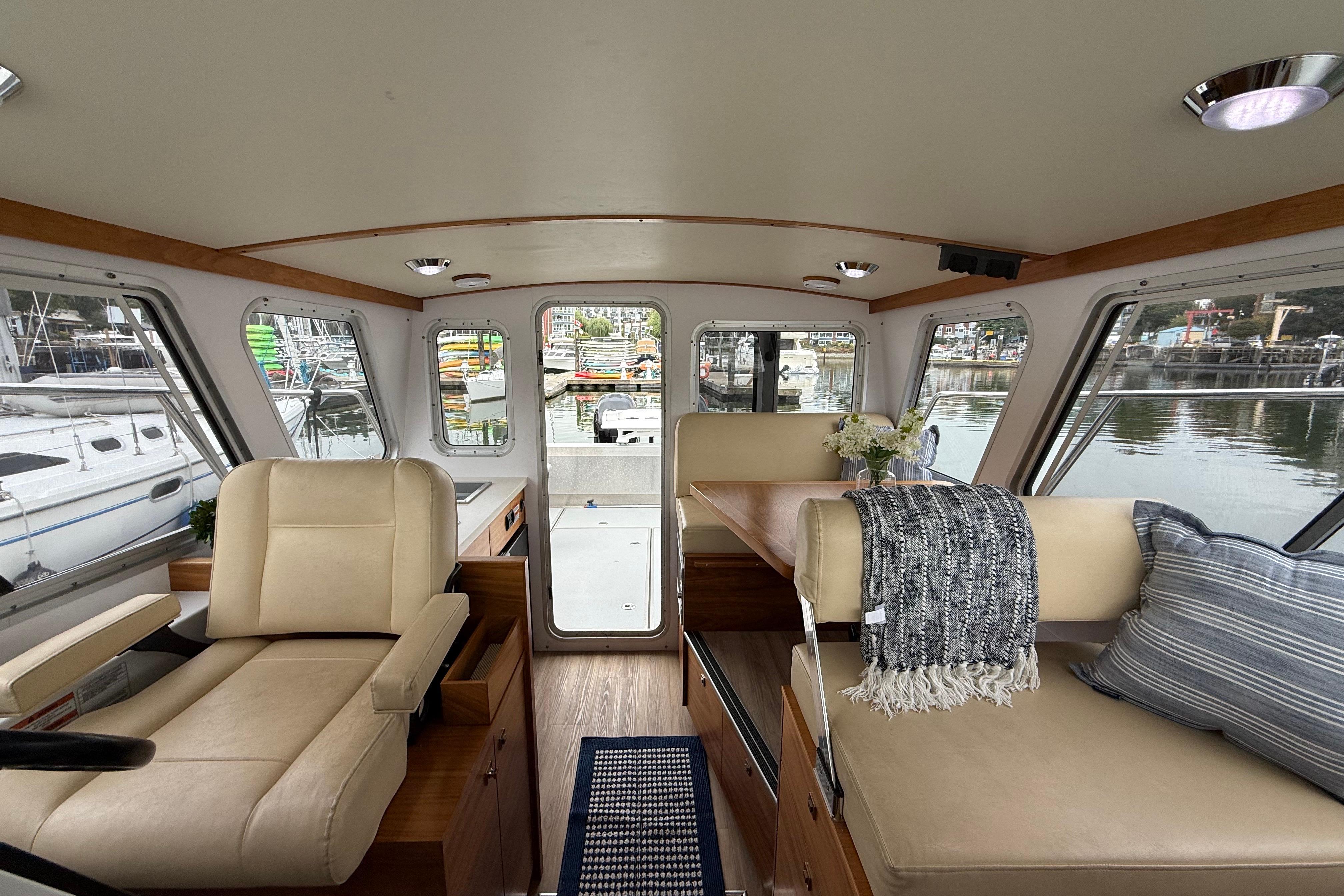 Interior of 2018 Coastal Craft 30 Profish boat with seating and table, docked at marina.