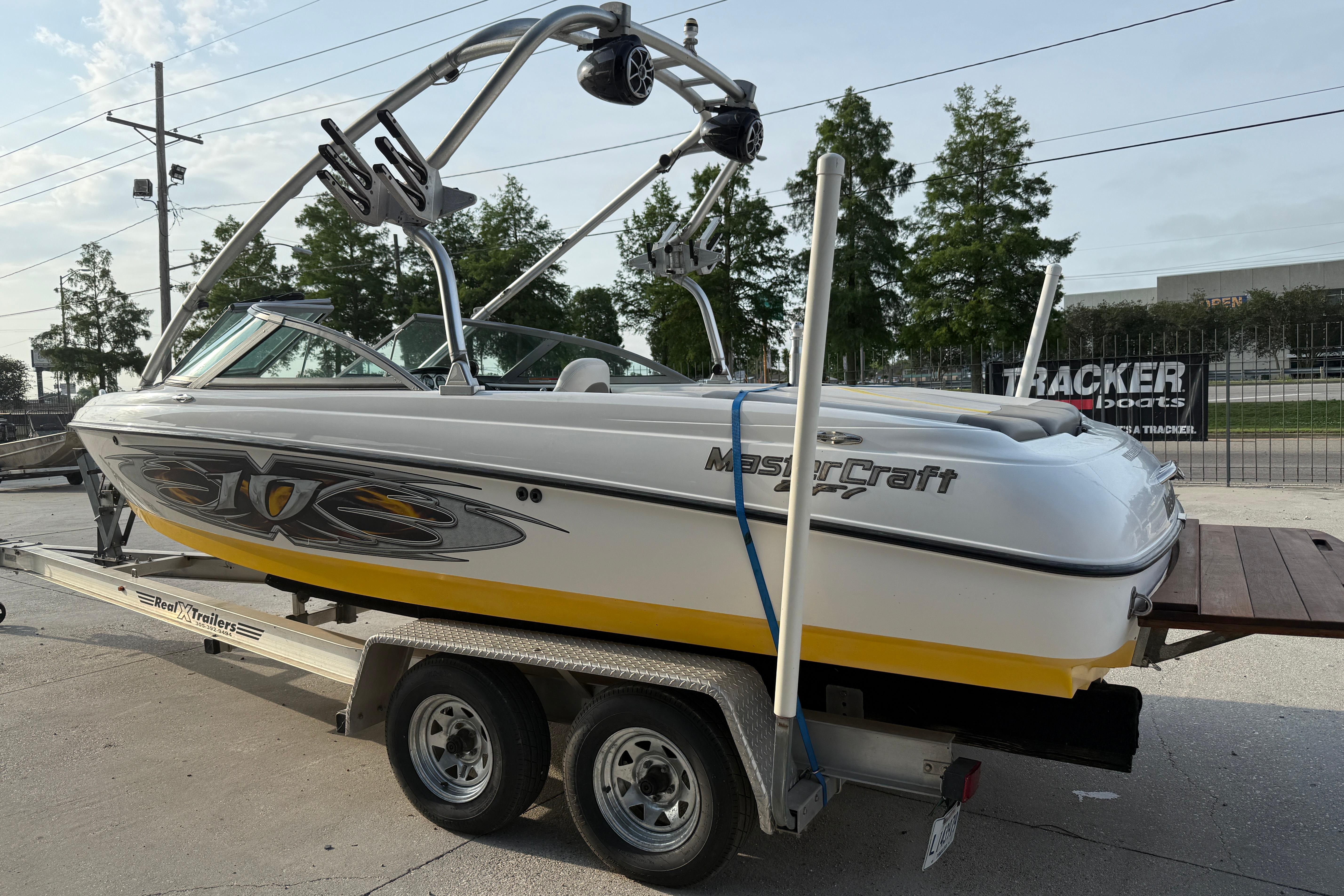 2005 MasterCraft X10 boat on trailer, featuring sleek design and vibrant yellow accents.