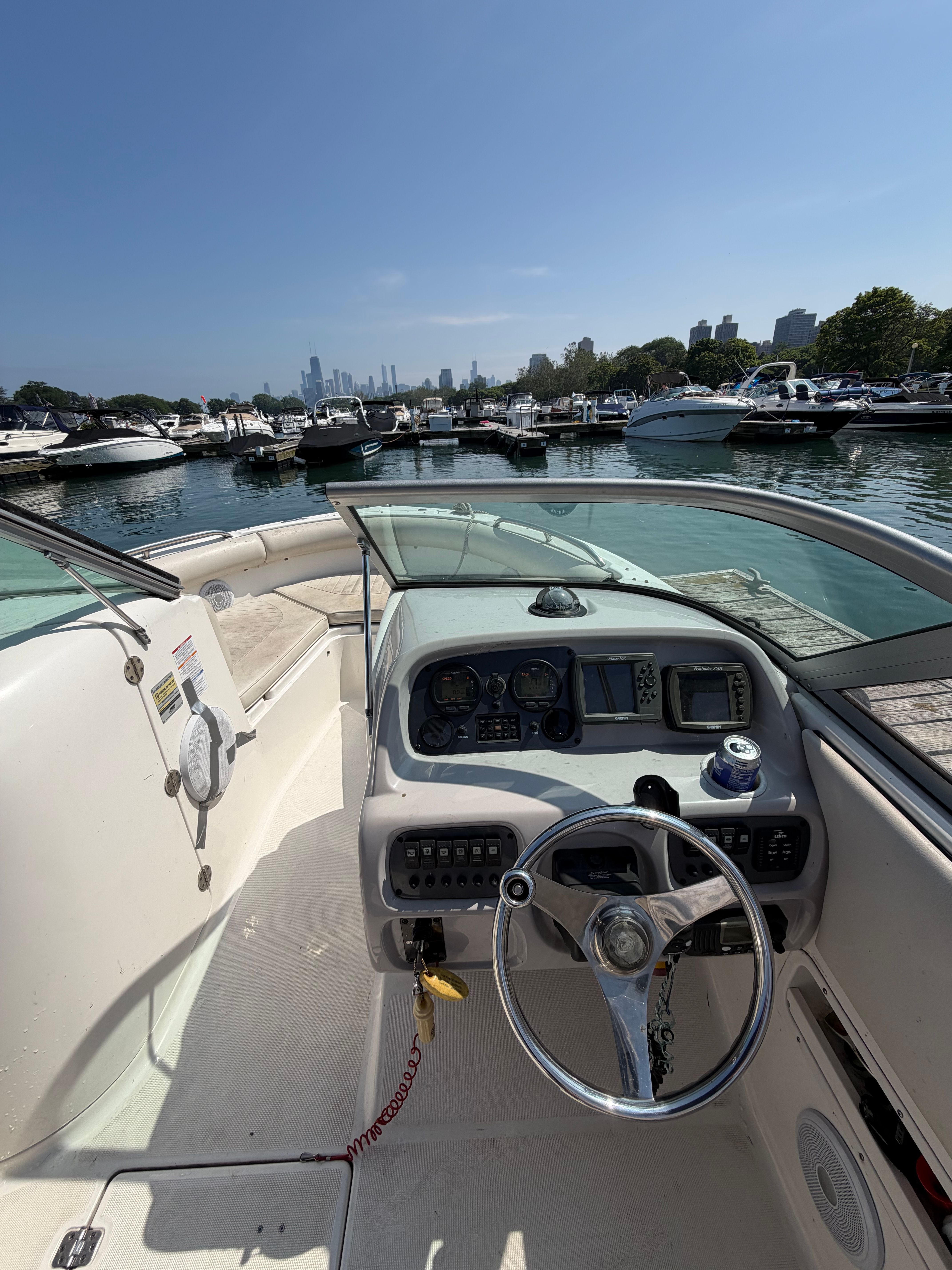 The cockpit of a 2005 Robalo R227 Dual Console boat, overlooking a marina.