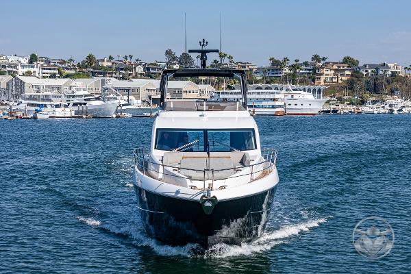 2025 Sunseeker Manhattan 68 yacht cruising in a scenic marina.