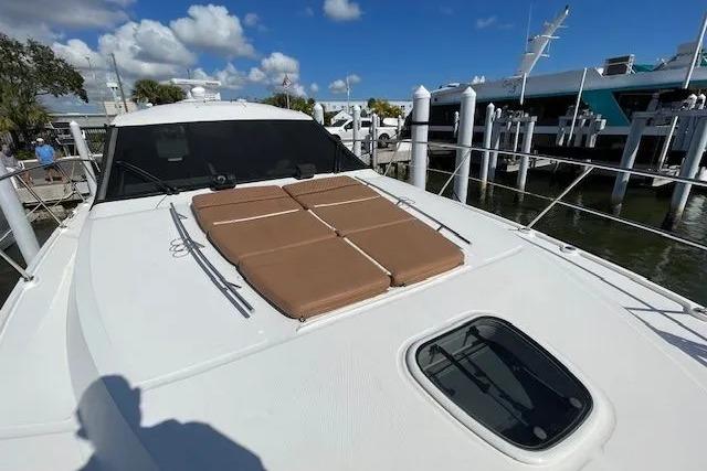 2016 Sea Ray Sundancer 510 yacht with sun pads, docked under a clear blue sky.