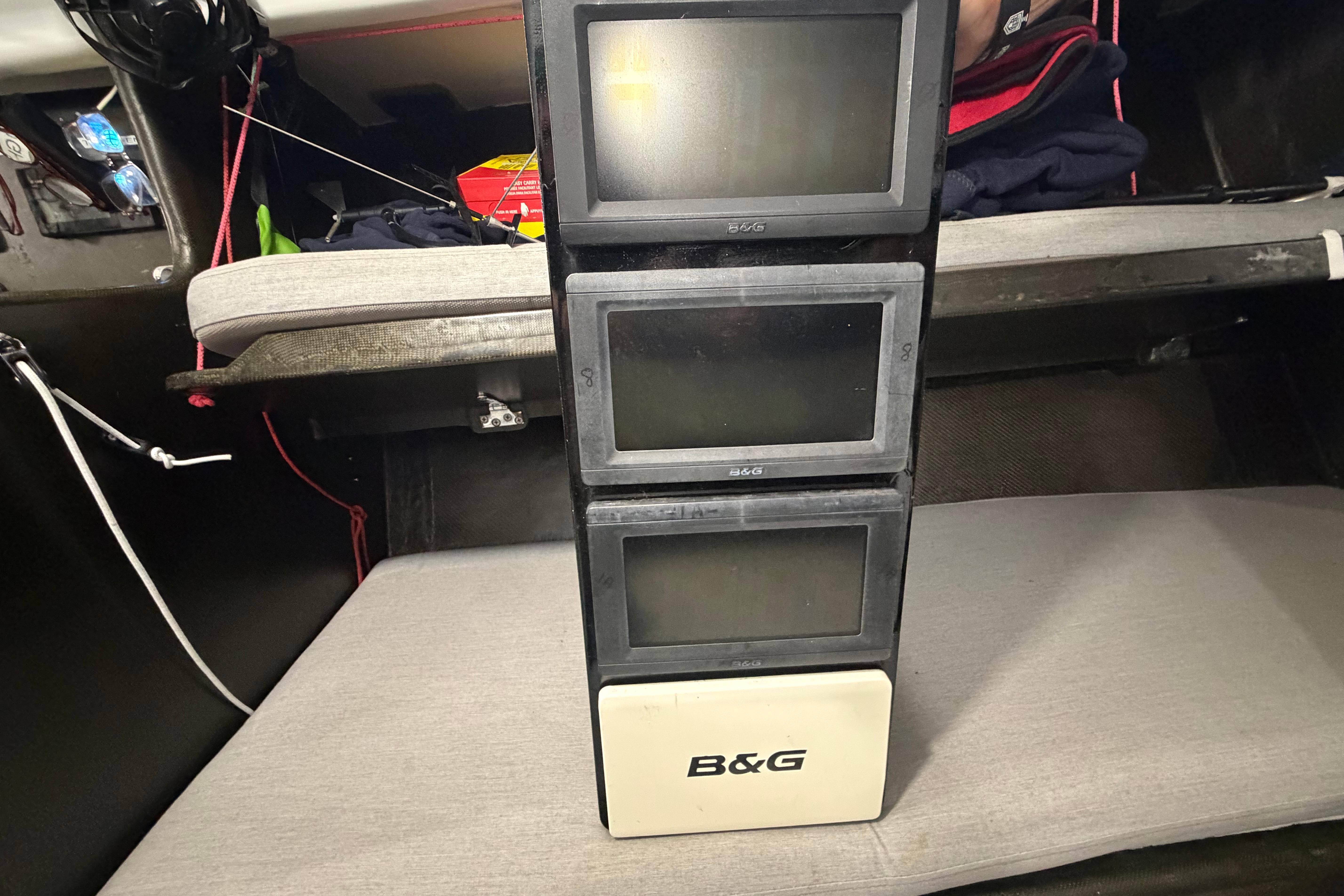 B&G navigation displays inside Andrews 63 yacht cabin, featuring stacked screens and seating area.