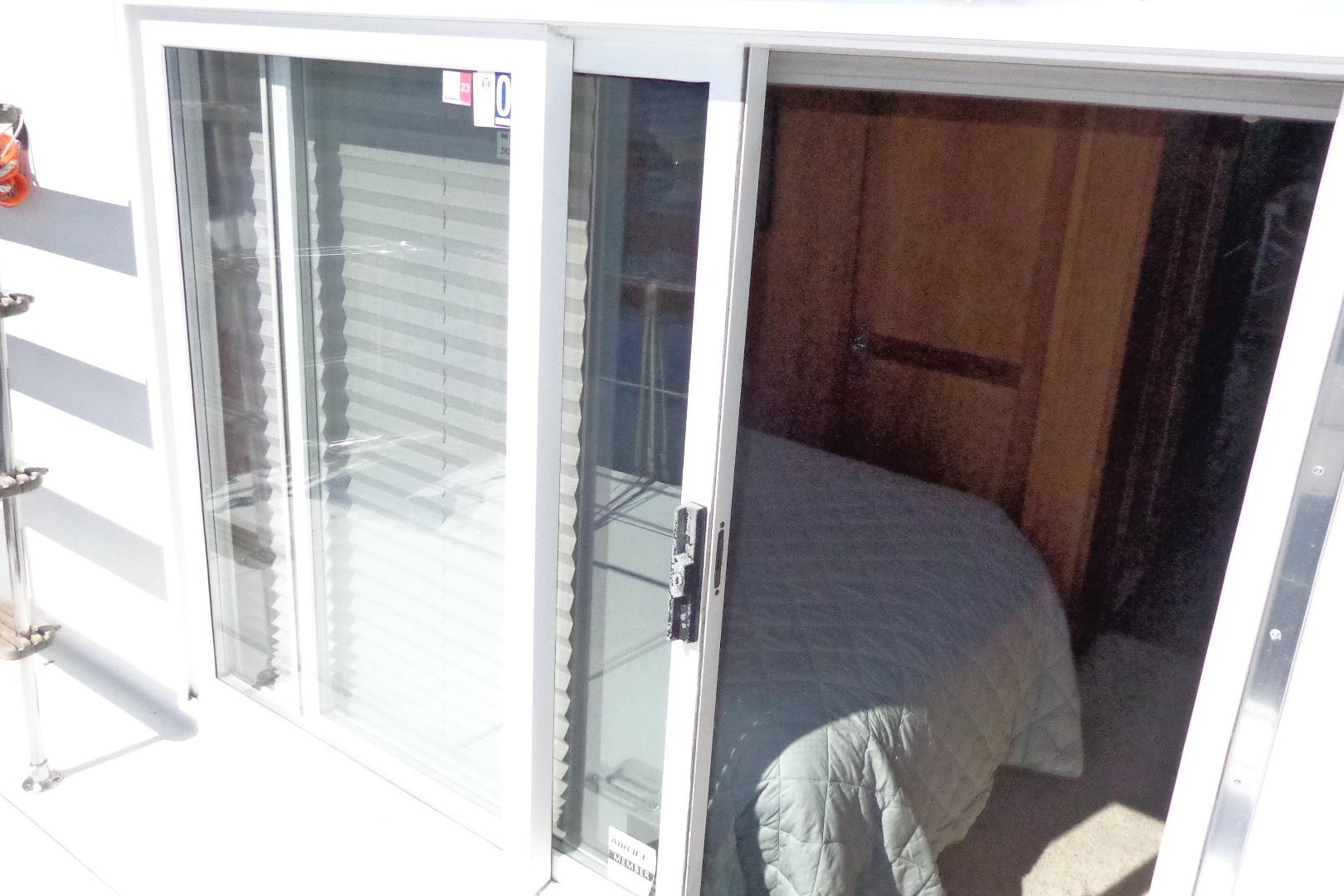 Sliding glass door on 1992 Cruise-A-Home Corsair 4200, revealing cozy interior with bed.